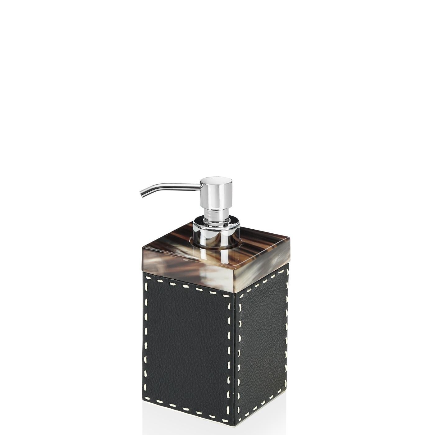 Il set Berenice è un accessorio raffinato per completare l'arredamento di qualsiasi bagno. Berenice comprende un dispenser di sapone, un portaspazzolino e un vassoio rivestito in pelle di Aida ciottolata, colore Onyx, con cuciture avorio fatte a