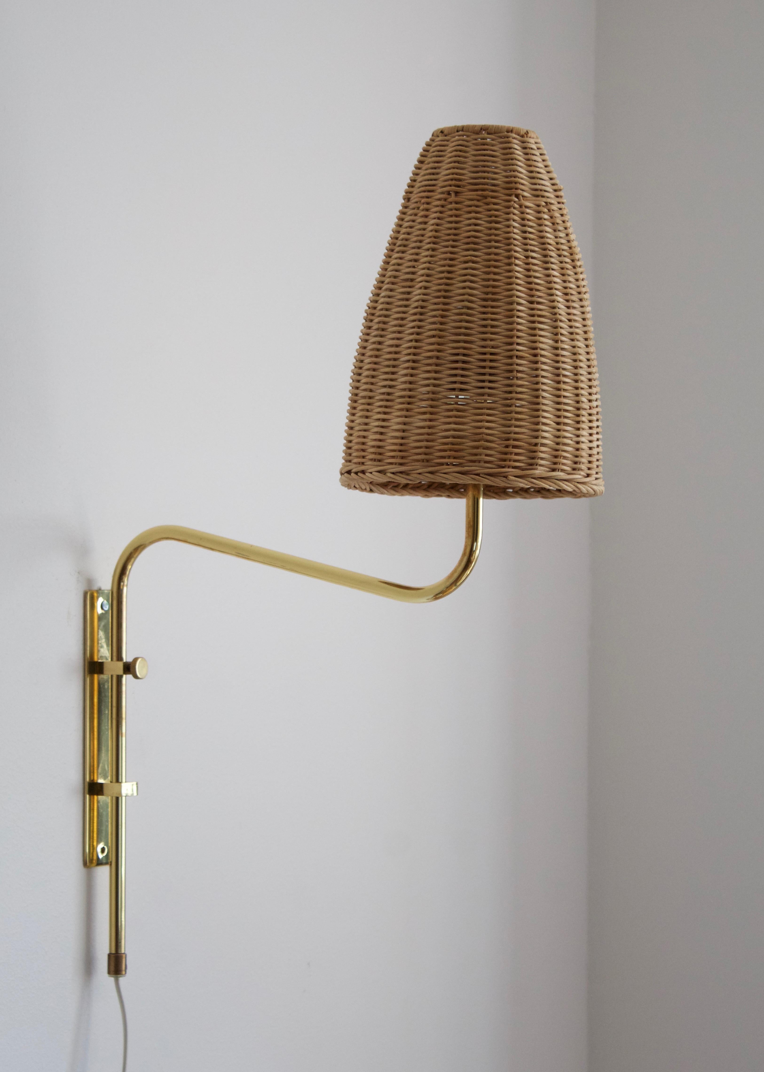 A wall light / wall sconce. Designed and produced by Bergboms, Sweden, c. 1970s. Labeled. Assorted vintage rattan lampshade.

Measurements include lampshade. 

Other designers of the period include Paavo Tynell, Hans Bergström, Josef Frank, and