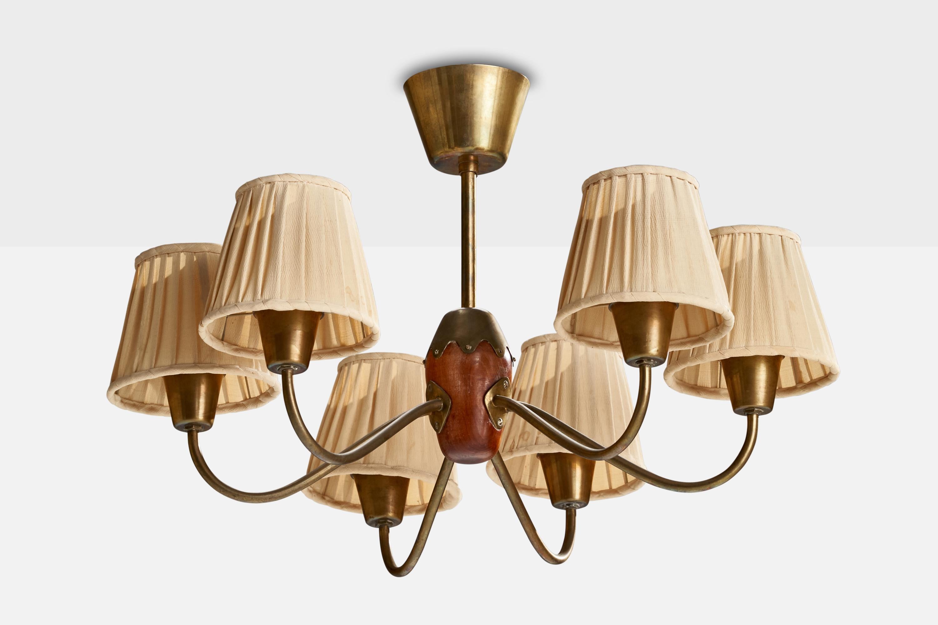 A brass, stained beech and beige fabric chandelier designed and produced by Bergboms, Sweden, 1940s.

Dimensions of canopy (inches): 3” H x 4.25” Diameter
Small tear in one of the shades
Socket takes standard E-26 bulbs. 6 socket.There is no maximum