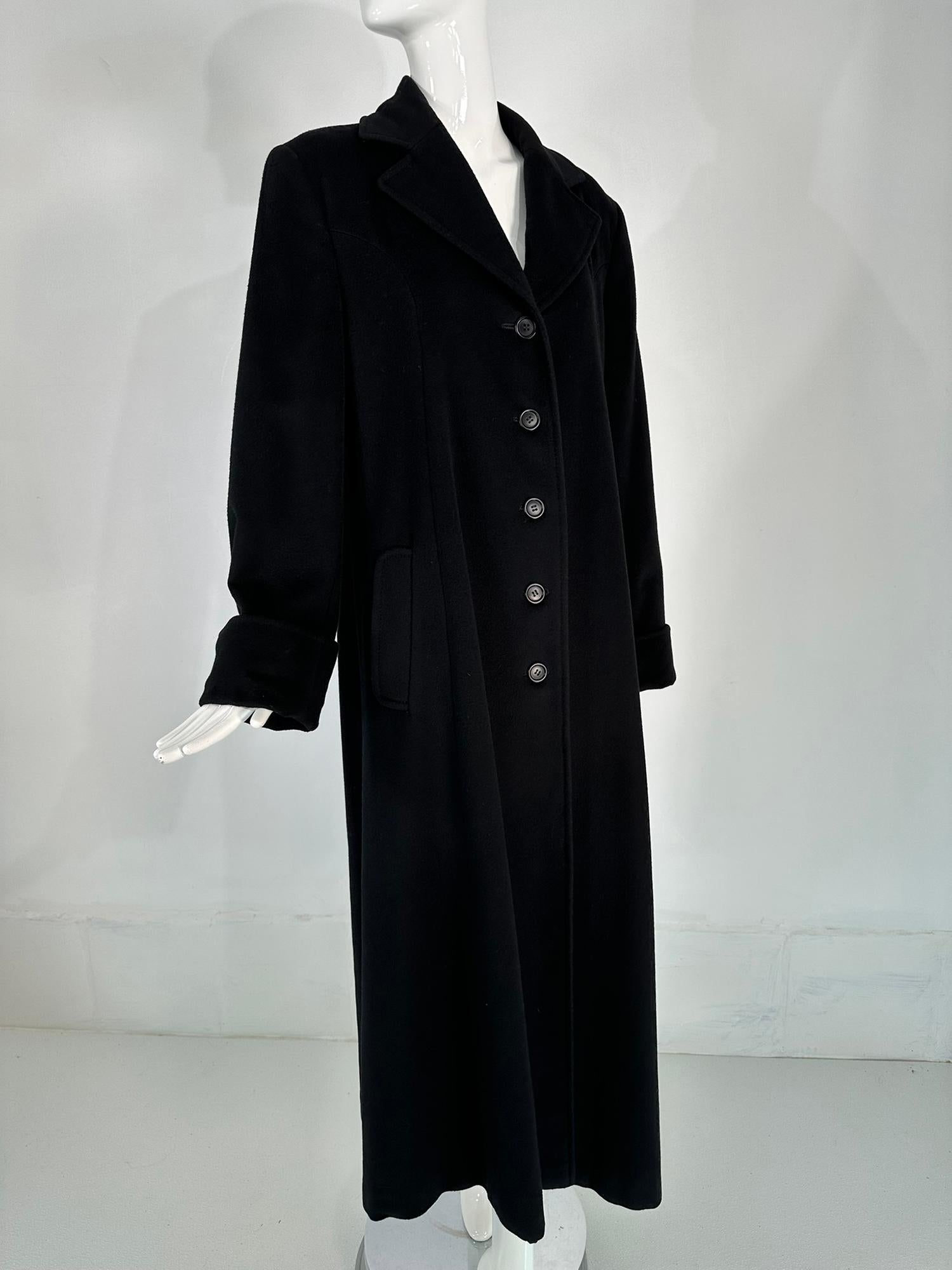 Bergdorf Goodman black cashmere overcoat from the 1990s. A statement making coat in luxurious black cashmere. Single breasted coat has notched lapels, the long sleeves have deep turn back cuffs. There are angled flap hip pockets. The coat back has