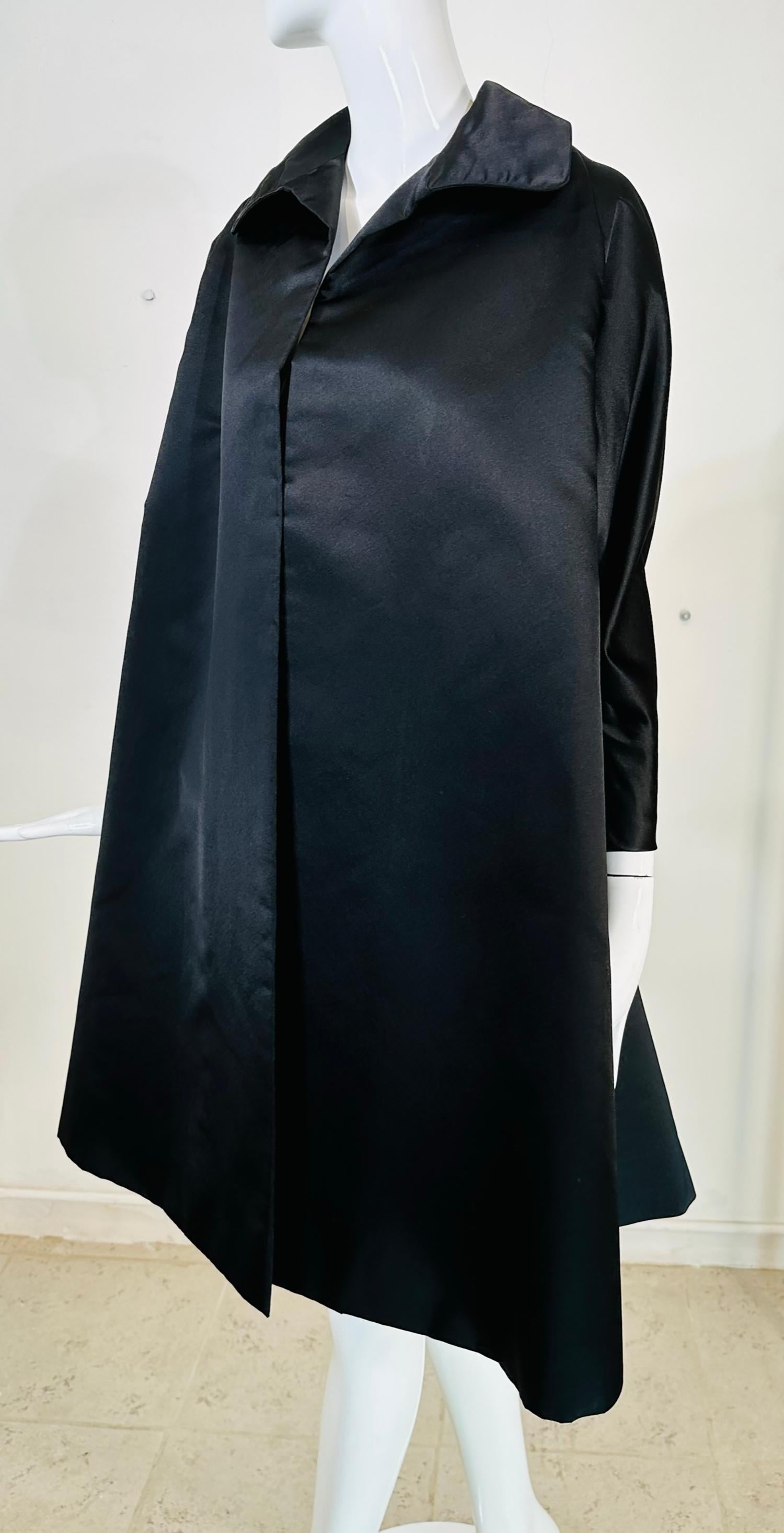 Manteau du soir en satin de soie noire de forme trapézoïdale de Bergdorf Goodman, datant des années 1950. Ce magnifique manteau est parfait pour toute occasion spéciale, je le considérerais comme un poids moyen pour l'automne ou le début de l'hiver.