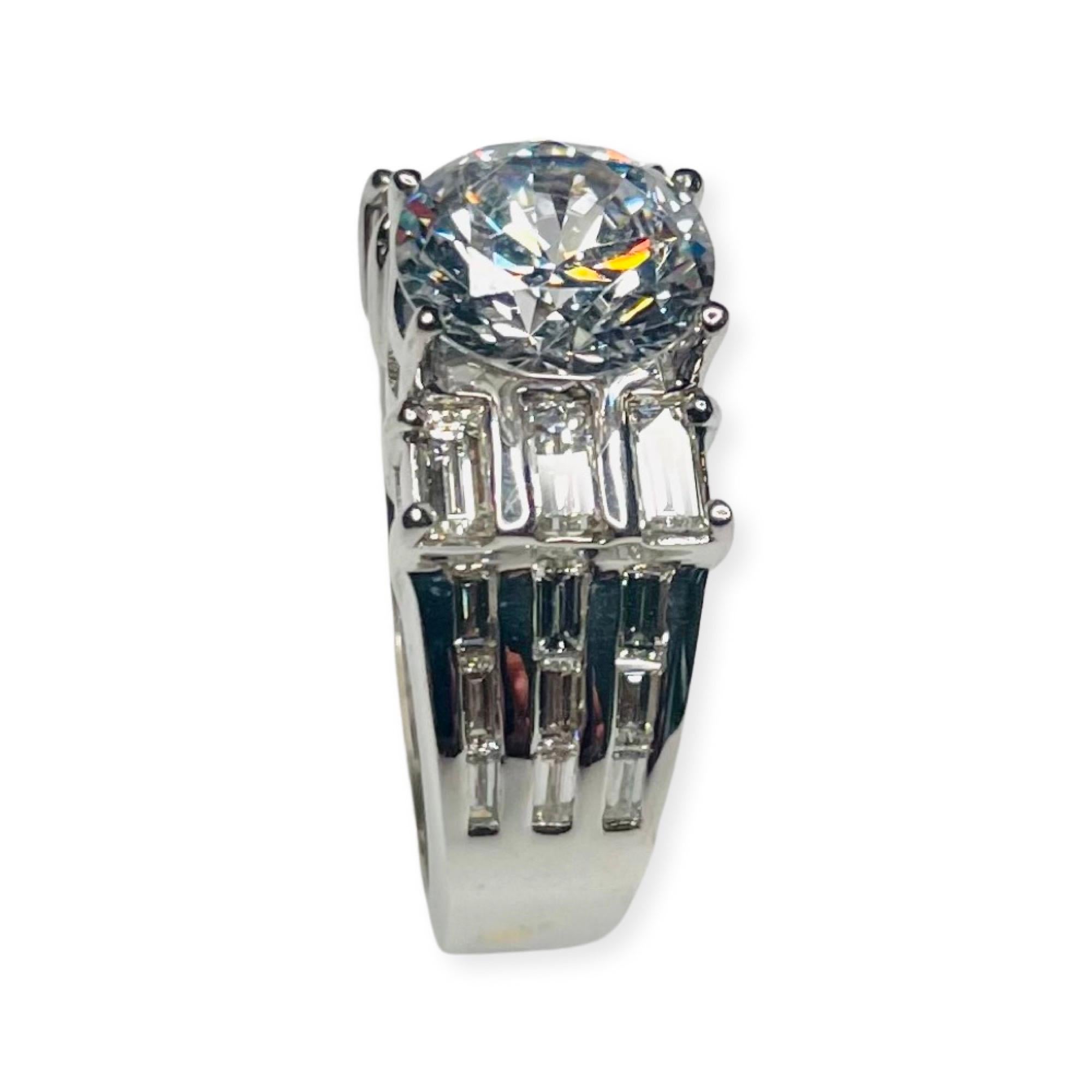 Bergio 18K White Gold Diamond Engagement Ring. It has a 9.0 mm cubic zirconia 4-split prong set in the center of the ring. This CZ is equivalent in size to a 3 carat diamond. This CZ can be replaced with a Moissanite, colored stone, Lab created or