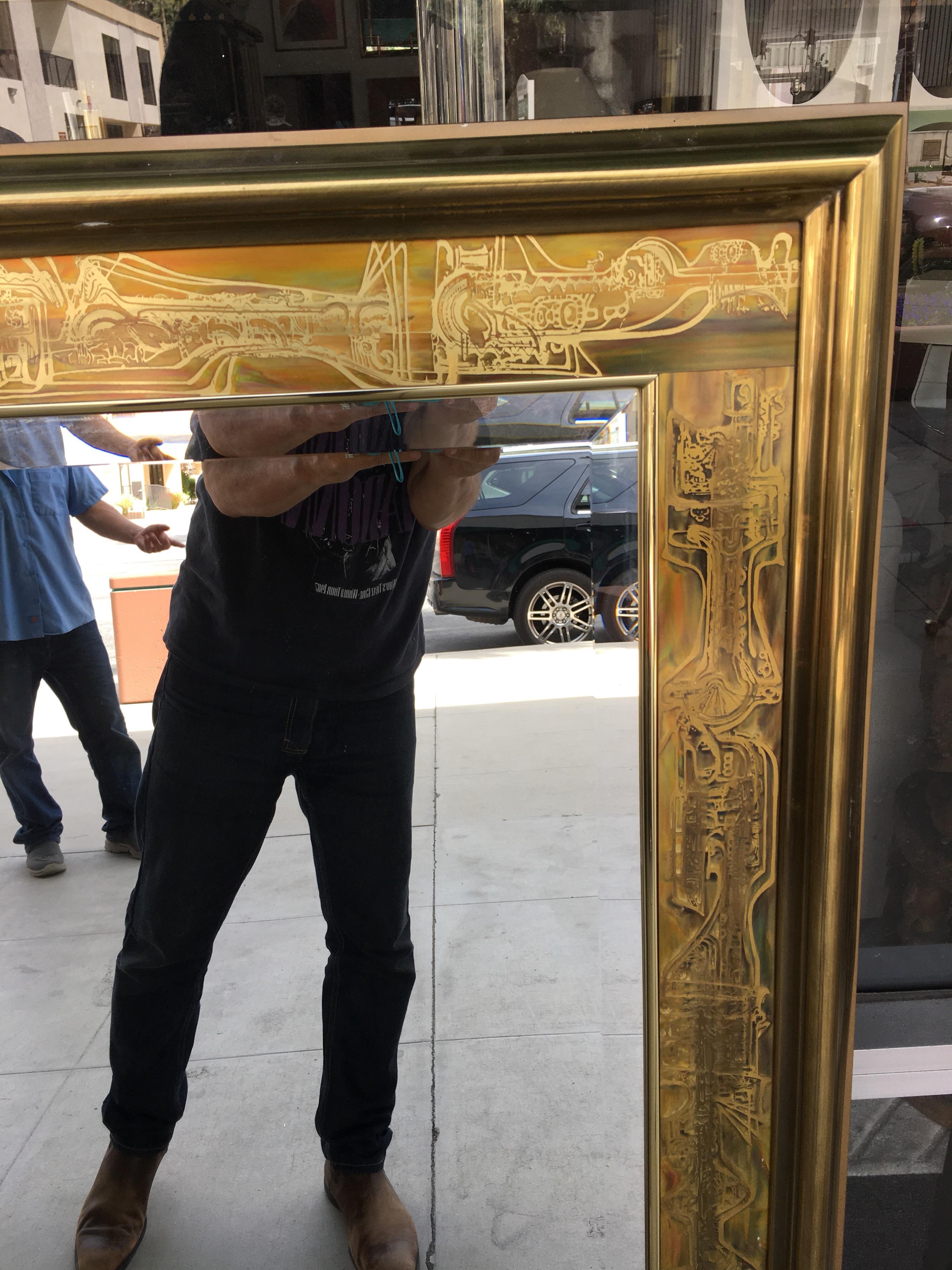 A lovely rare mirror designed by Bernhard Rohne for Mastercraft. Most mirrors that were made by Mastercraft are wood with brass trim. This is all brass and the acid etched design are on the entire 4 sides of the mirror. Matching pair of dressers