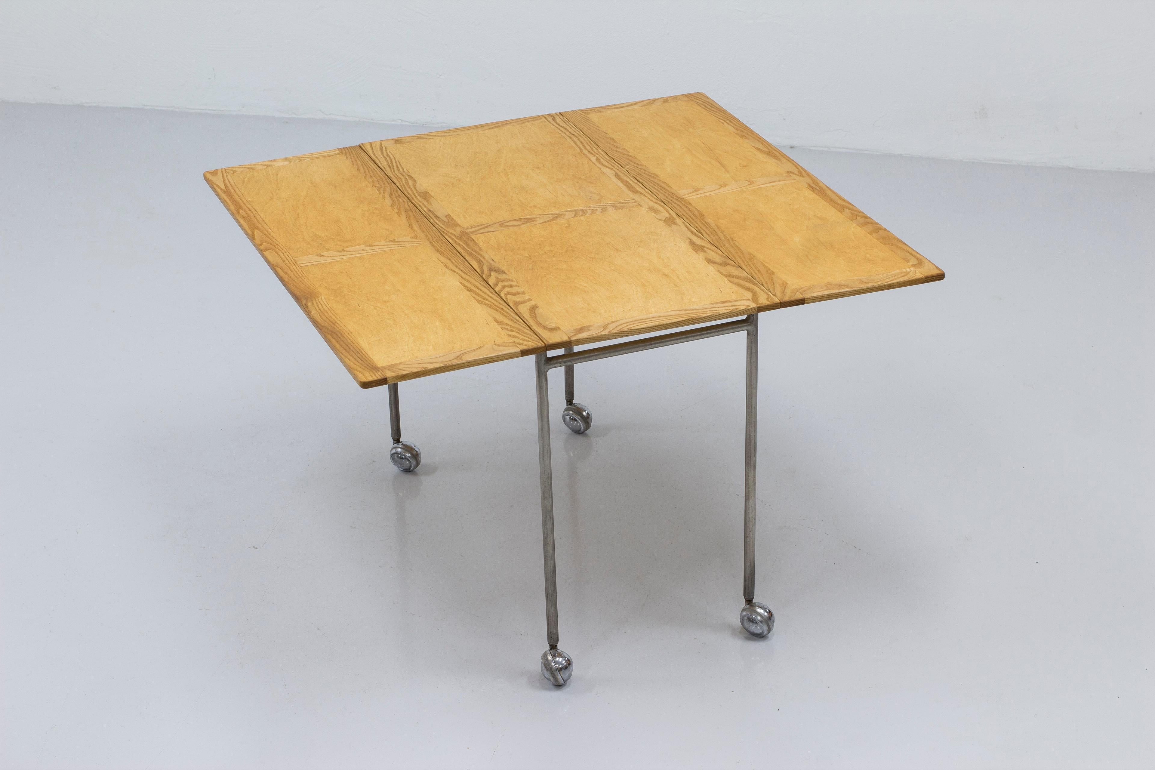 Extendable side table model Berit designed by Bruno Mathsson. Produced by Firma Karl Mathsson in Värnamo Sweden during the 1950s. Steel base on wheels with a ash and birch table top with very nice contrasting grain. The table extends from 40-100 cm