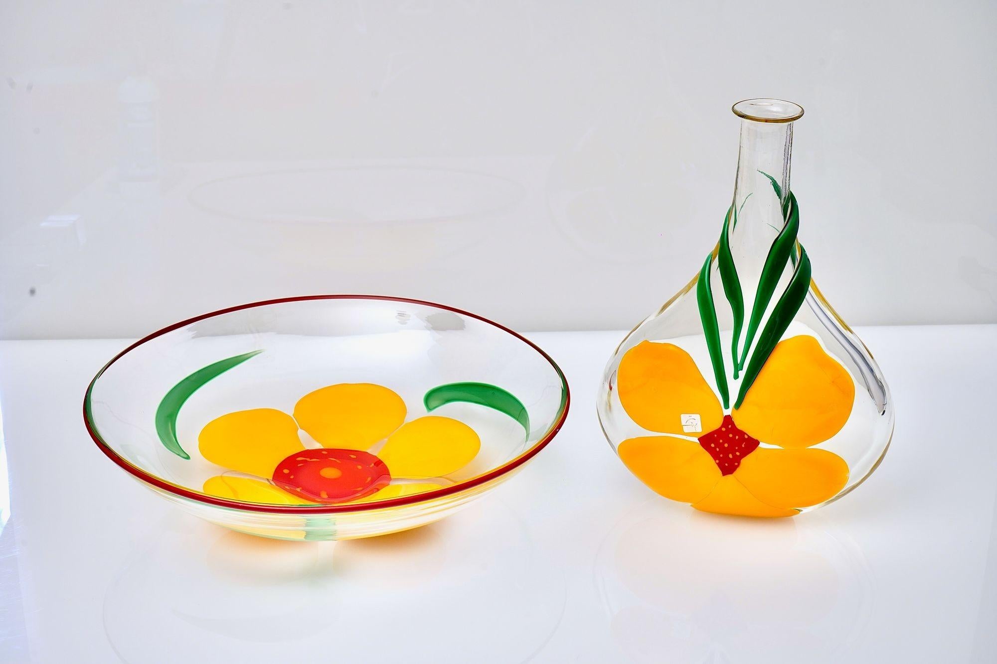 Raro conjunto de jarrón y cuenco Singed Pauly de Berit Johansson, diseñadora sueca que trabajó y trabaja para las mejores empresas vidrieras. Aporta frescura al diseño con su uso del color y temas principalmente florales.

El diseño está realizado