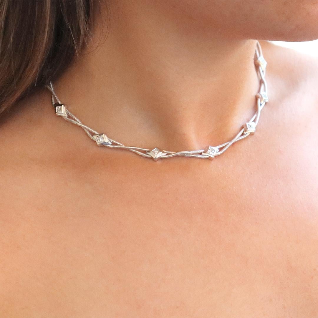 Beautiful solitaire princess cut diamonds are bezel set within slider style kite shape settings, handcrafted in 18K white gold and linked together with a crossed-over 18K snake chain. A very stylish necklace that may be worn every day or dressed up