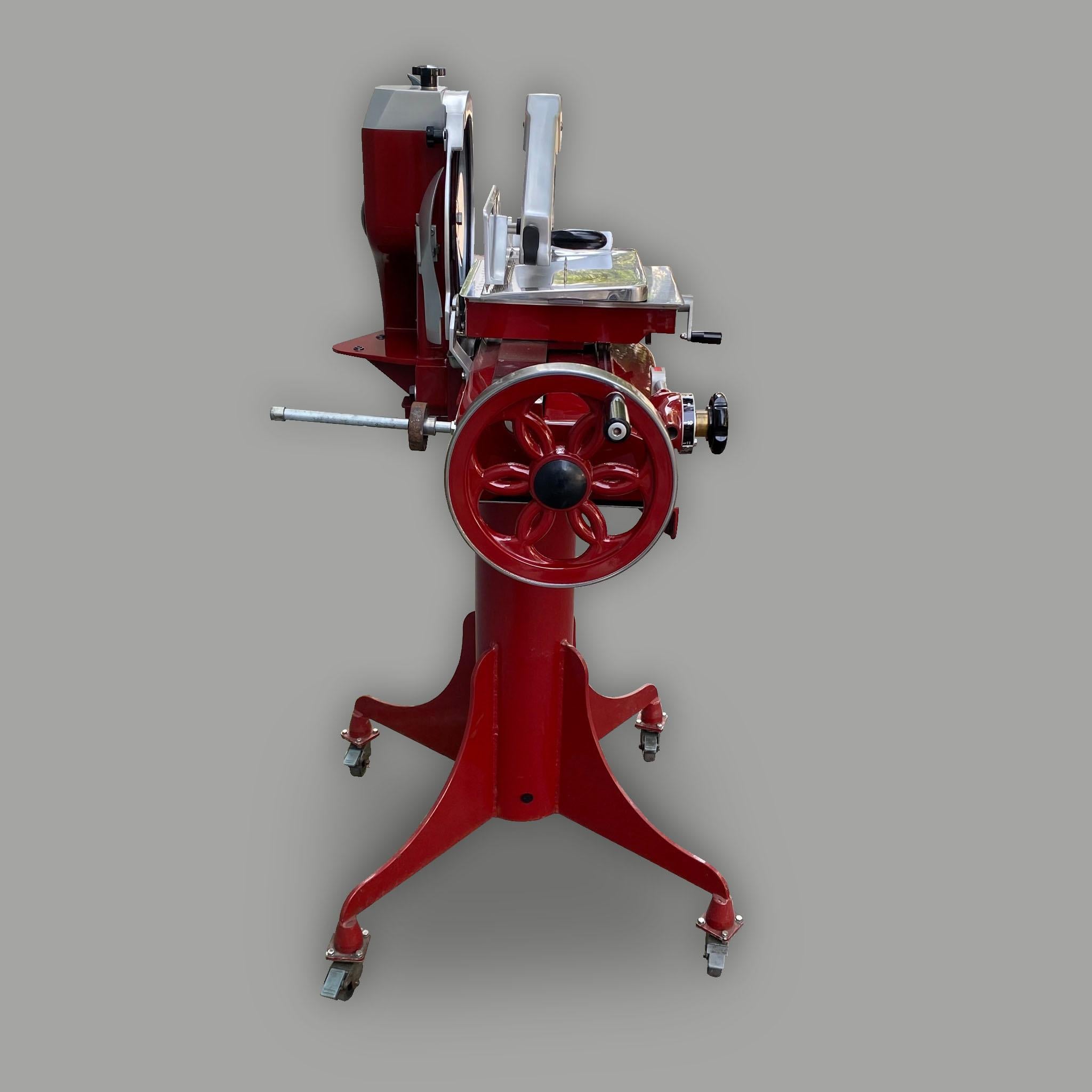 Eine wichtige, in Italien hergestellte Berkel Prosciutto-Schneidemaschine, Modell 330M. Die Schneidemaschine besteht aus zwei Teilen: dem Sockel mit 4 Rollen und der Maschine selbst.

Der ikonische Schwungradmechanismus hilft dem Benutzer, eine