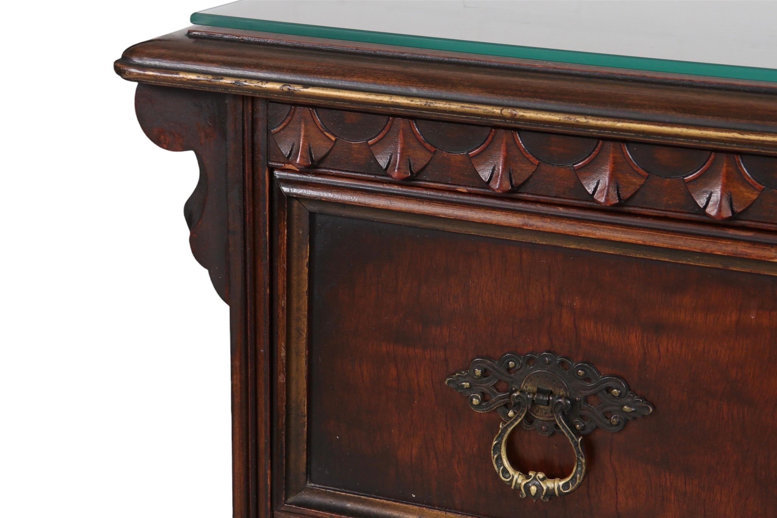 A Berkey and Gay painted chest in walnut, with a protective glass top. Two over two dovetailed drawers are framed with ornate carved moldings. The lower drawers give the look of four with a center panel, decorated with a gilt stenciled plant that