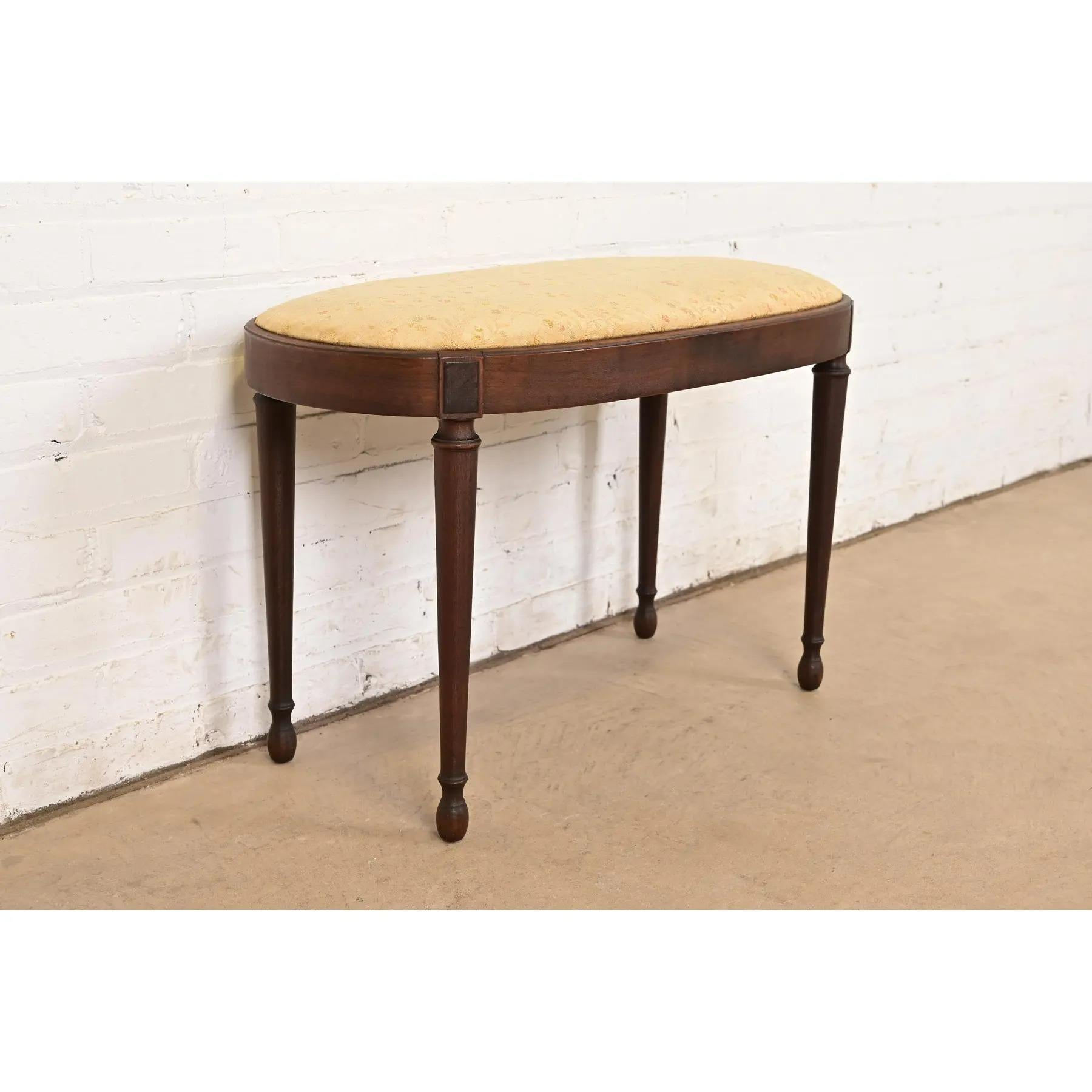 A gorgeous antique French Regency Louis XVI style vanity bench or stool

By Berkey & Gay

USA, Circa 1920s

Carved walnut, with upholstered seat.

Measures: 28.25