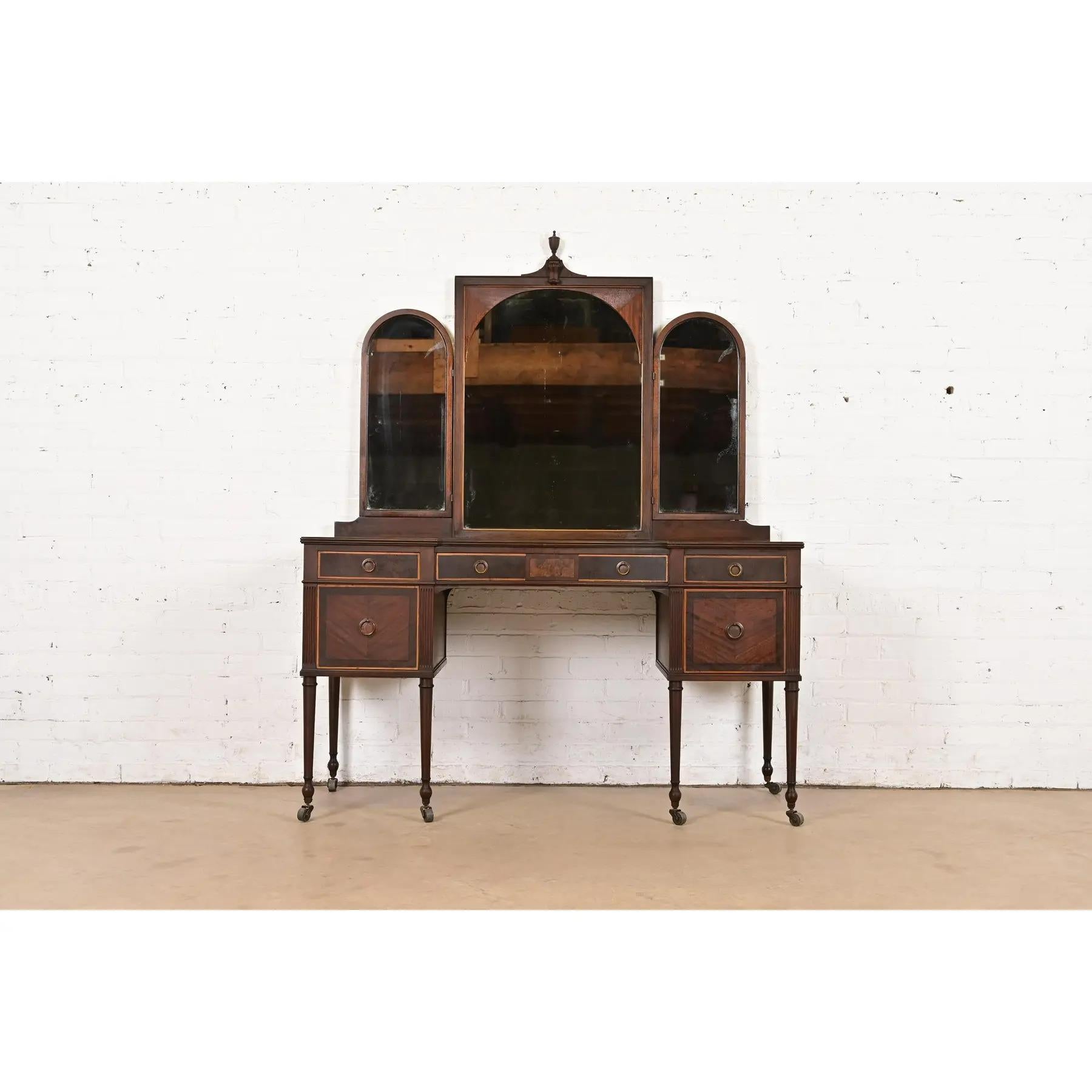 A gorgeous antique French Regency Louis XVI style vanity dresser with tri-fold mirror

By Berkey & Gay

USA, Circa 1920s

Carved walnut, with inlaid mahogany and burled walnut, and original brass hardware.

Measures: 54