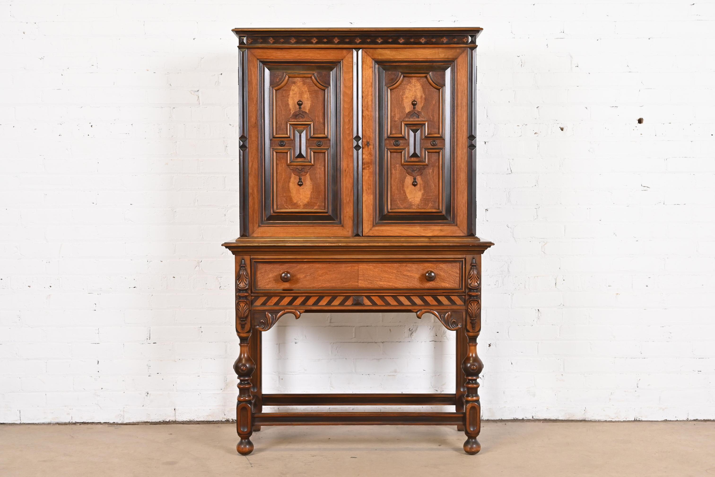 An exceptional English Jacobean style bookcase, china hutch, or bar cabinet

By Berkey & Gay

USA, Circa 1920s

Ornate carved walnut, with inlaid burl wood front.

Measures: 38