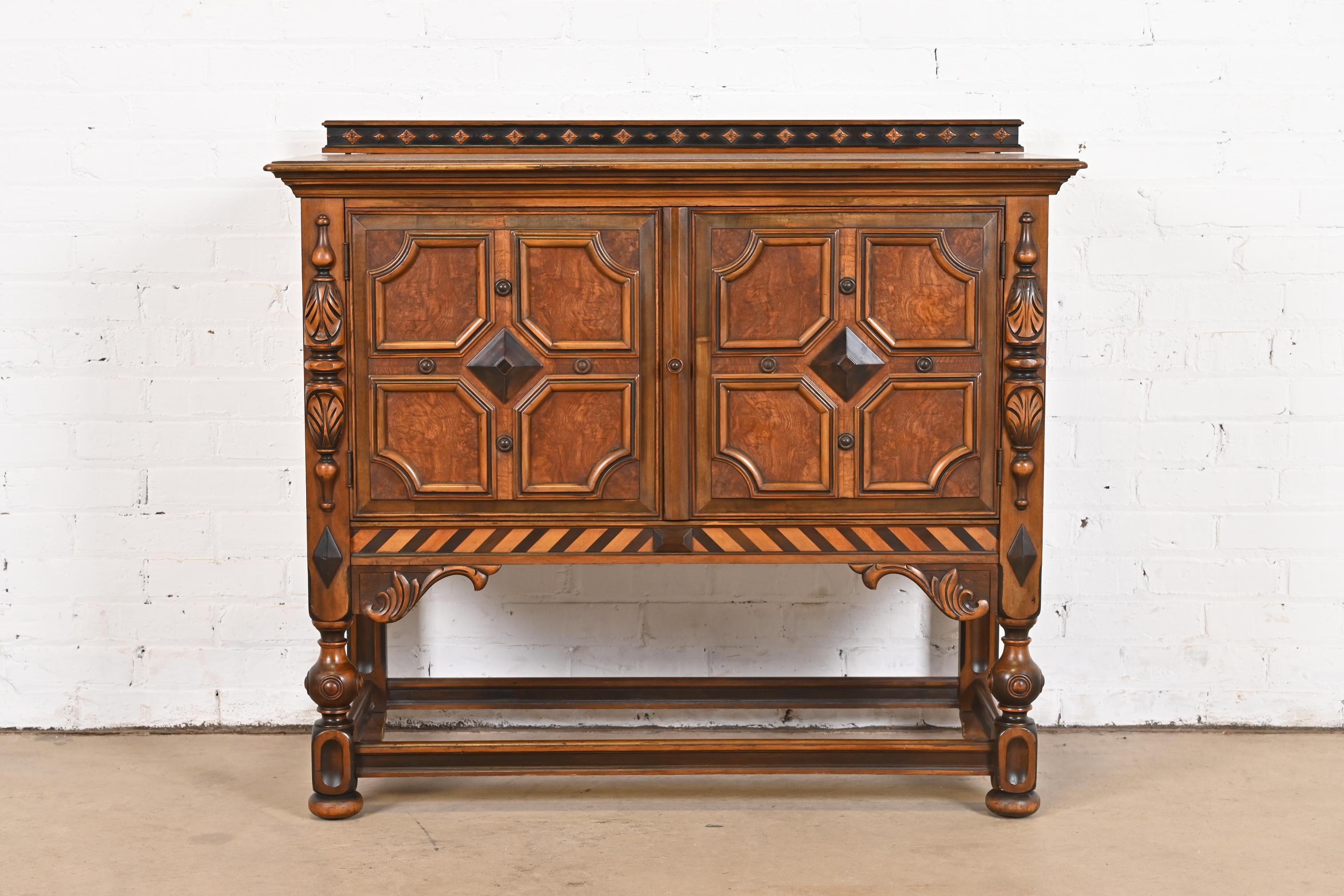 An exceptional English Jacobean style sideboard buffet, credenza, or bar cabinet

By Berkey & Gay

USA, Circa 1920s

Ornate carved walnut, with inlaid burl wood door fronts.

Measures: 41