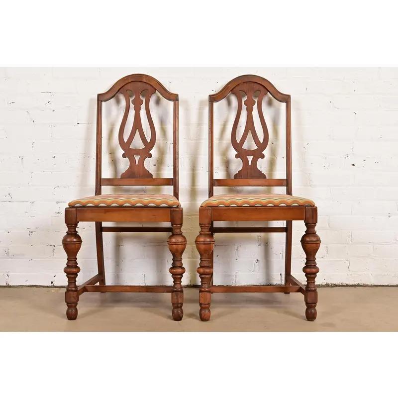 Une belle paire de chaises d'appoint ou de chaises de salle à manger anglaises anciennes de style Jacobean ou Tudor.

À la manière de Berkey & Gay

États-Unis, vers 1920

Encadrement en noyer sculpté, avec sièges rembourrés.

Dimensions : 19 