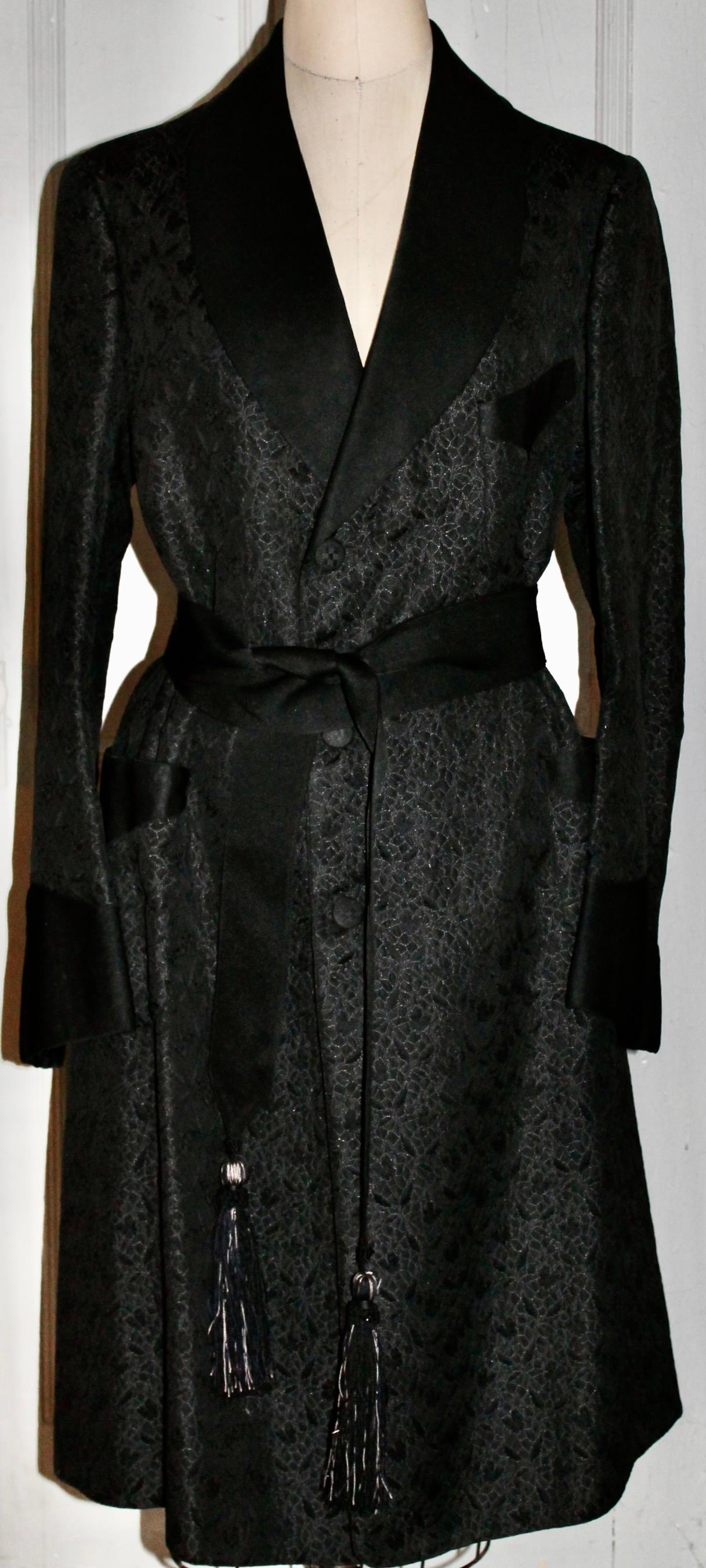 Une veste/un manteau de smoking en soie de Coates R. Merwin. 681 Fifth Avenue NYC. Taille moyenne, ceinture avec pompons en soie, entièrement doublée. Deux labels, l'un daté (29 novembre 1923) et portant le nom du propriétaire d'origine.