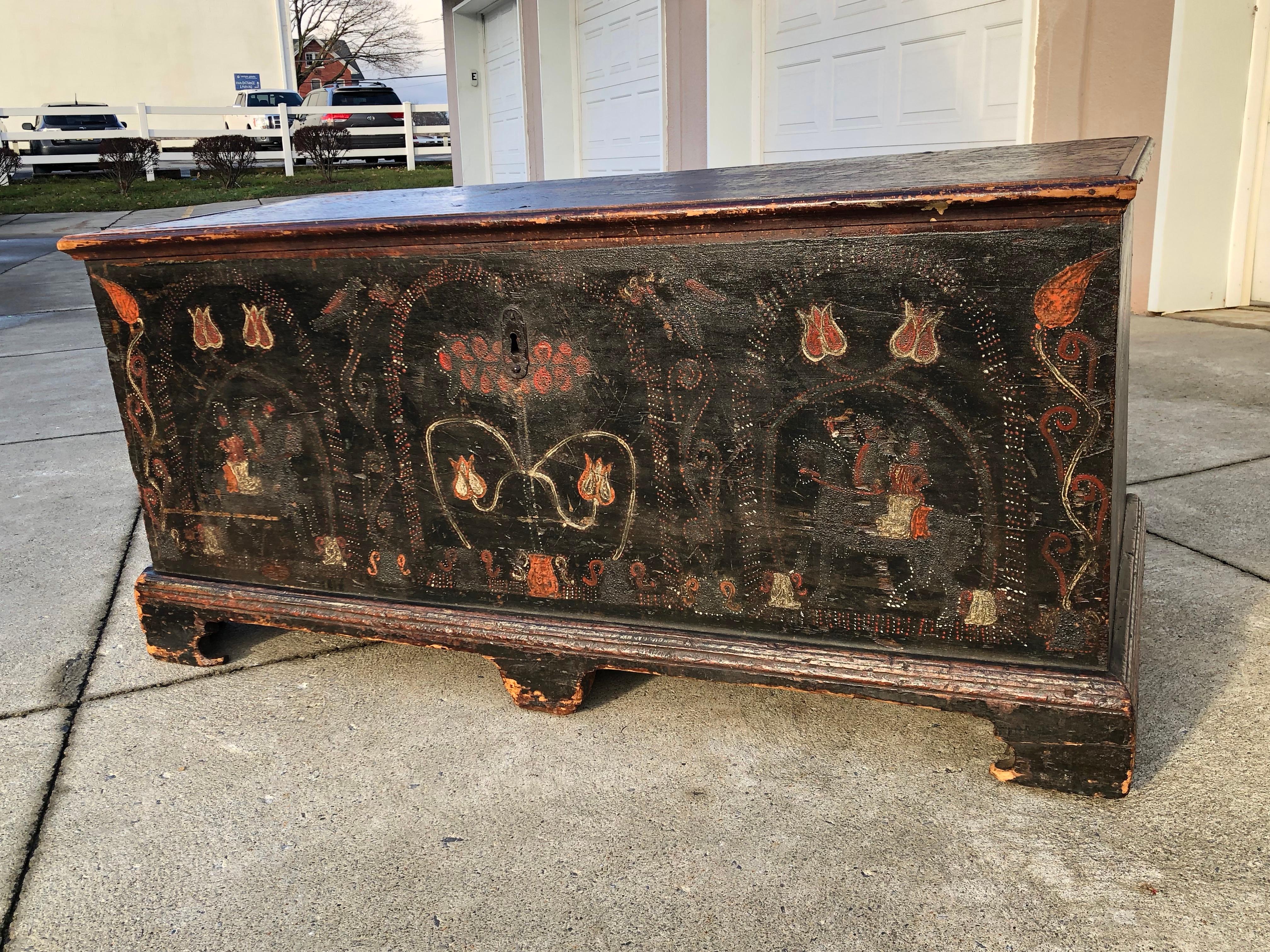 A very rare horse and rider painted blanket chest with three panels in the front the centre showing stylized pot of flowers which is flanked by two panels of man an women of horseback possibly Martha and George Washington There are two more floral