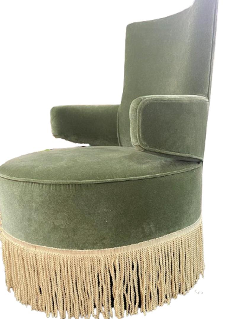 Upholstered armchair with fringes.