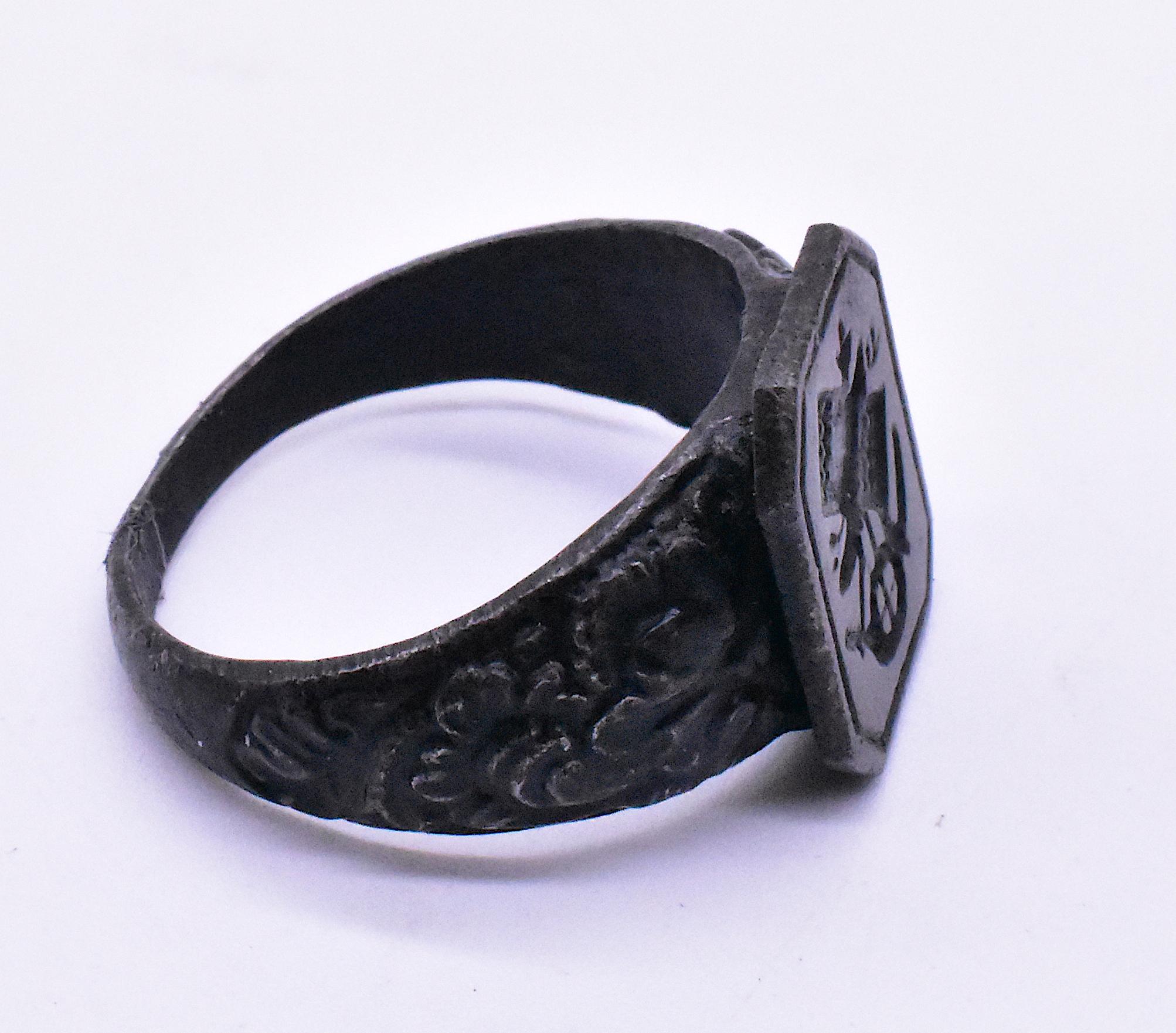 This is a wonderful signet ring made of Berlin iron and carved with what appears to be agricultural tools, including a scythe, wisps of grain from a harvest, and what appears to be a symbol for a parcel of agricultural land. The scythe symbolizes
