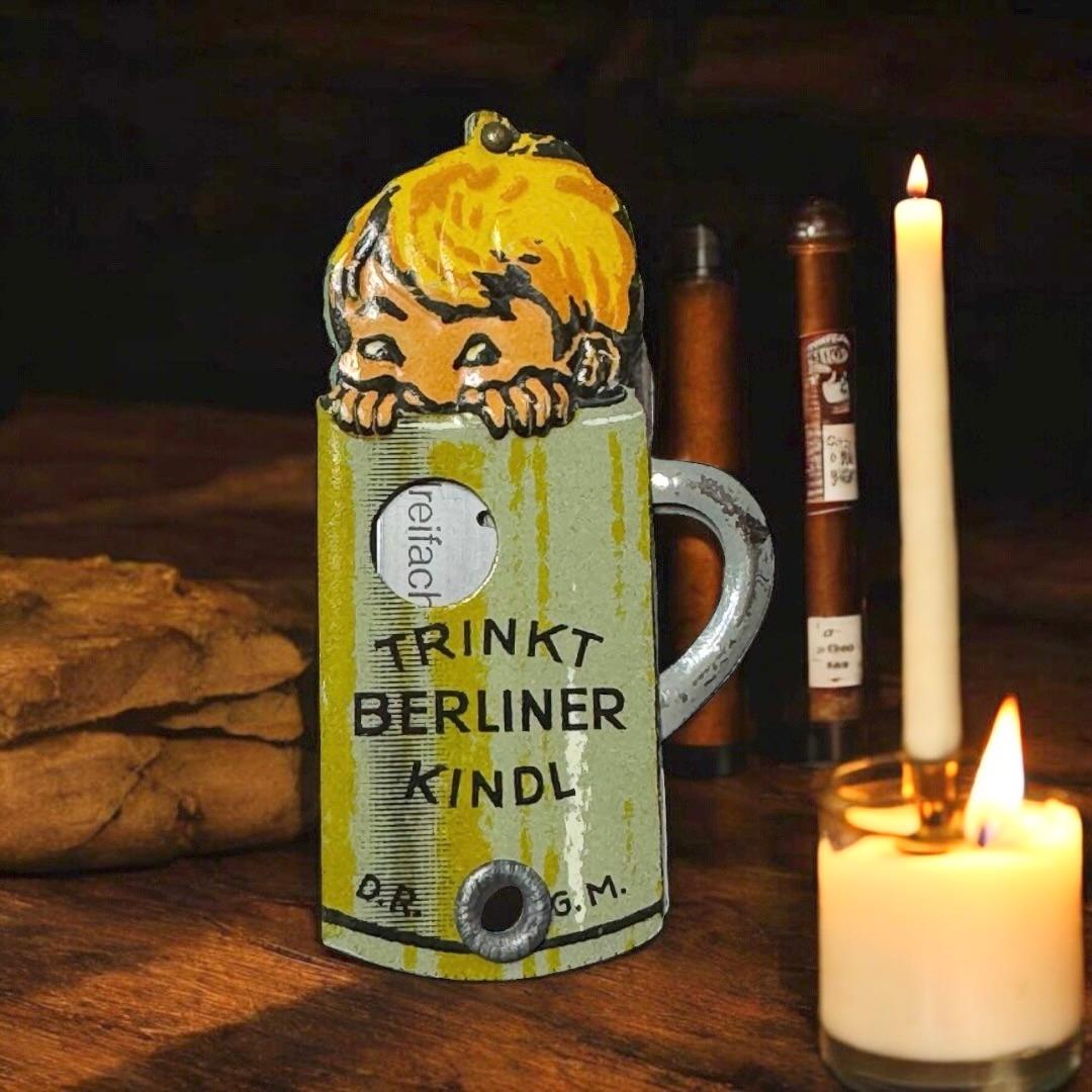 A Berlin Kindl (Child) Beer advertising cigar cutter. Some wear with a nice patina, but this is old-age. Made of lithographed sheet metal and a shaving blade. This item was a giveaway from the Brewery to customers in Berlin, Germany. A beautiful