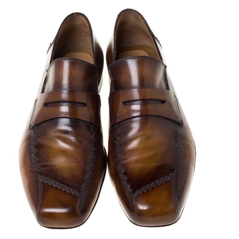 Right on style and comfort, this pair of loafers by Berluti will make a great addition to your shoe collection. They've been crafted from leather in brown and styled with Penny keeper straps on the vamps. Snug leather insoles and an elegant finish