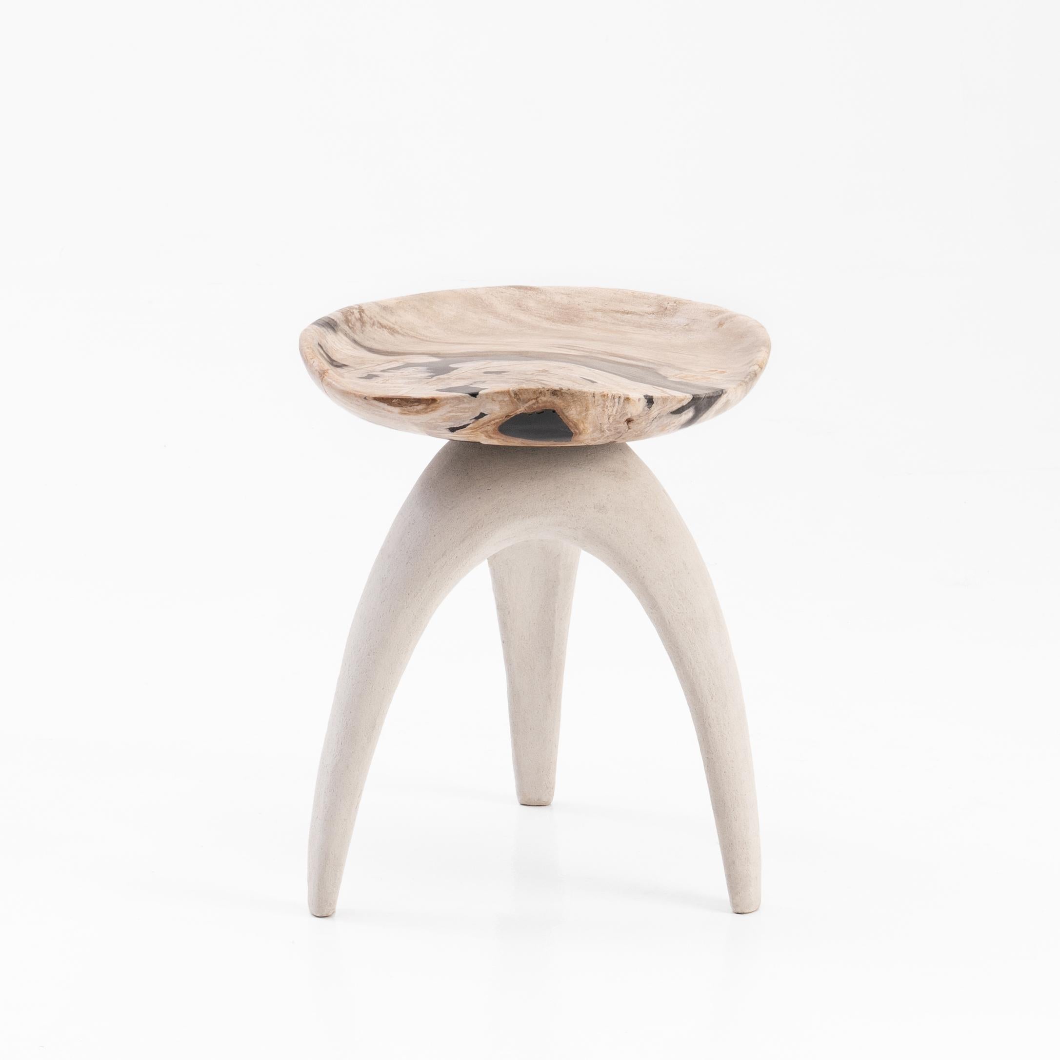 The ‘Bermuda Triangle’ sculptural stool features a solid hand-carved petrified wood saddle seat, perched upon an organic shaped tripod base made from limestone composite.
 
Petrified wood is created from fossilised trees transformed into stone by a
