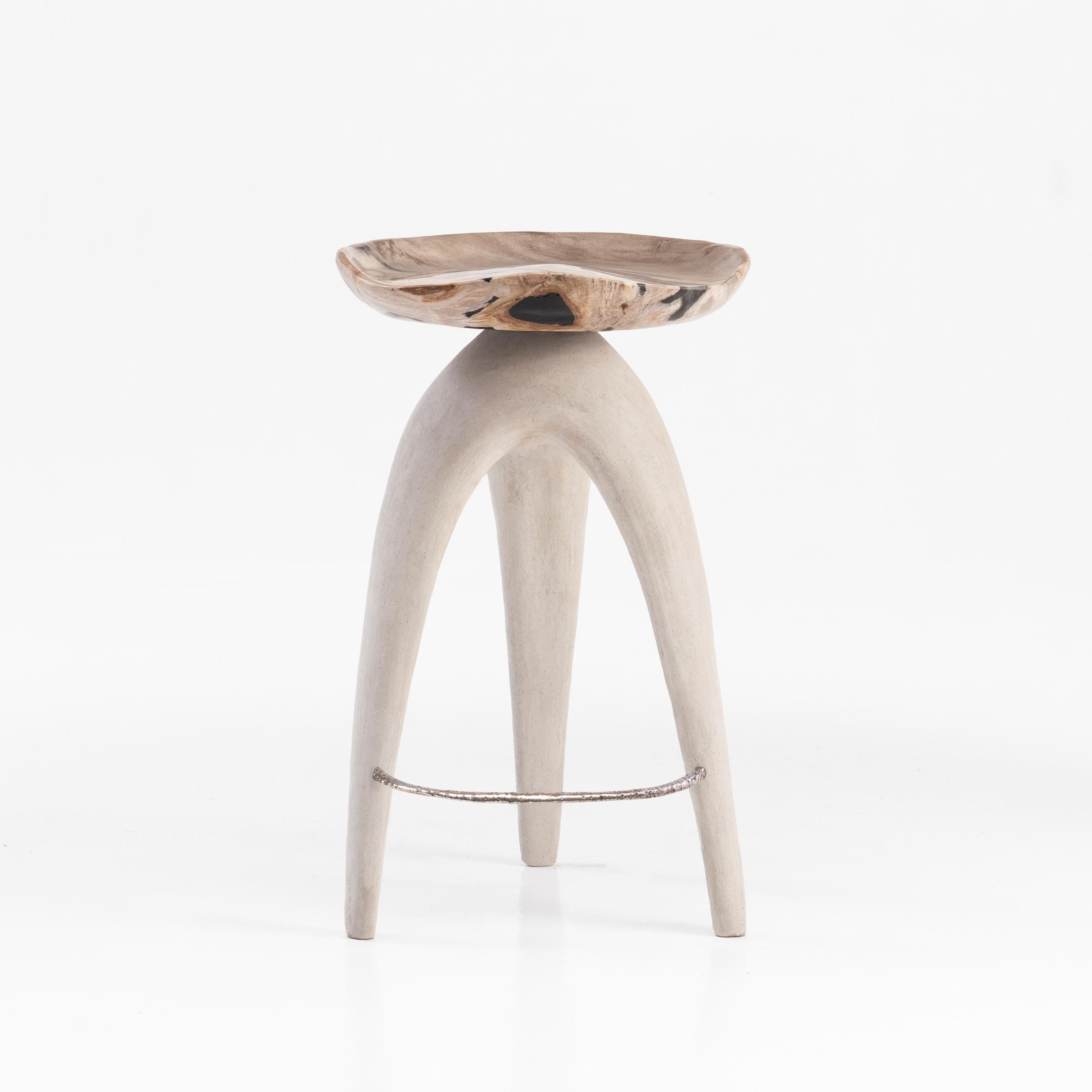 The ‘Bermuda Love Triangle’ sculptural stool features a solid hand-carved petrified wood saddle seat, perched upon an organic shaped tripod base made from limestone composite.
 
Petrified wood is created from fossilised trees transformed into stone