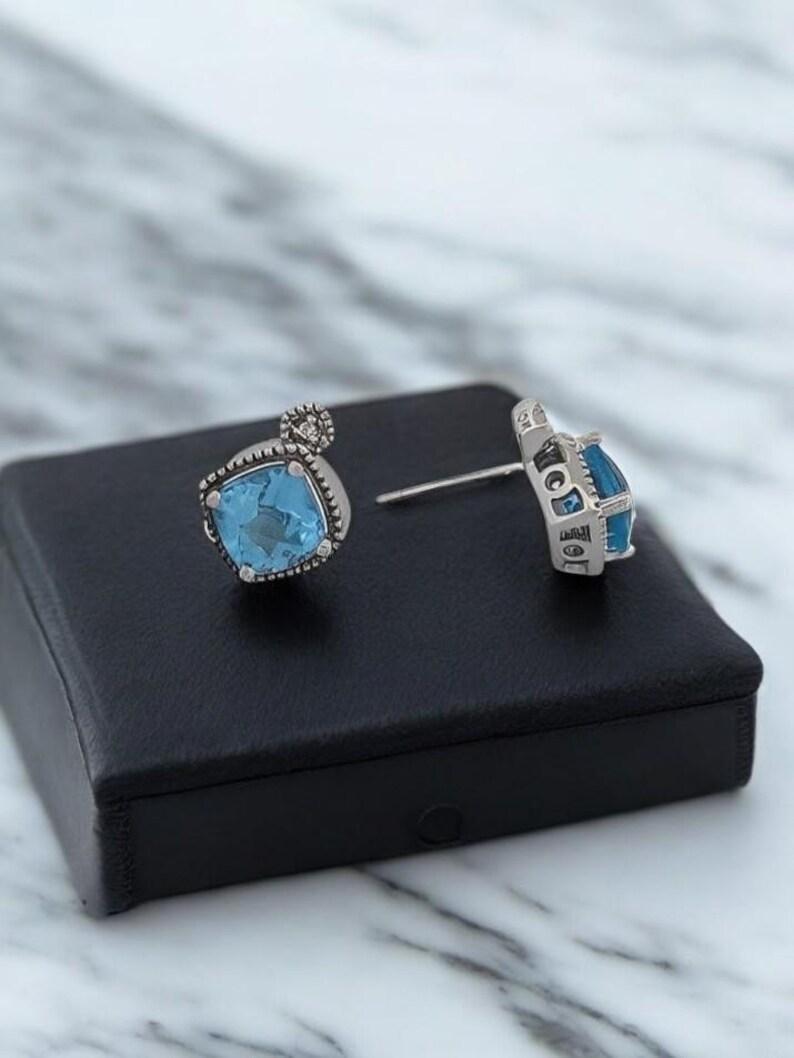Add a splash of color to your collection with the Bernadette .23 Ctw Blue Topaz Stud Earrings. These stunning earrings feature vibrant blue topaz gemstones totaling .23 carats, beautifully set in a sterling silver prong setting. The combination of