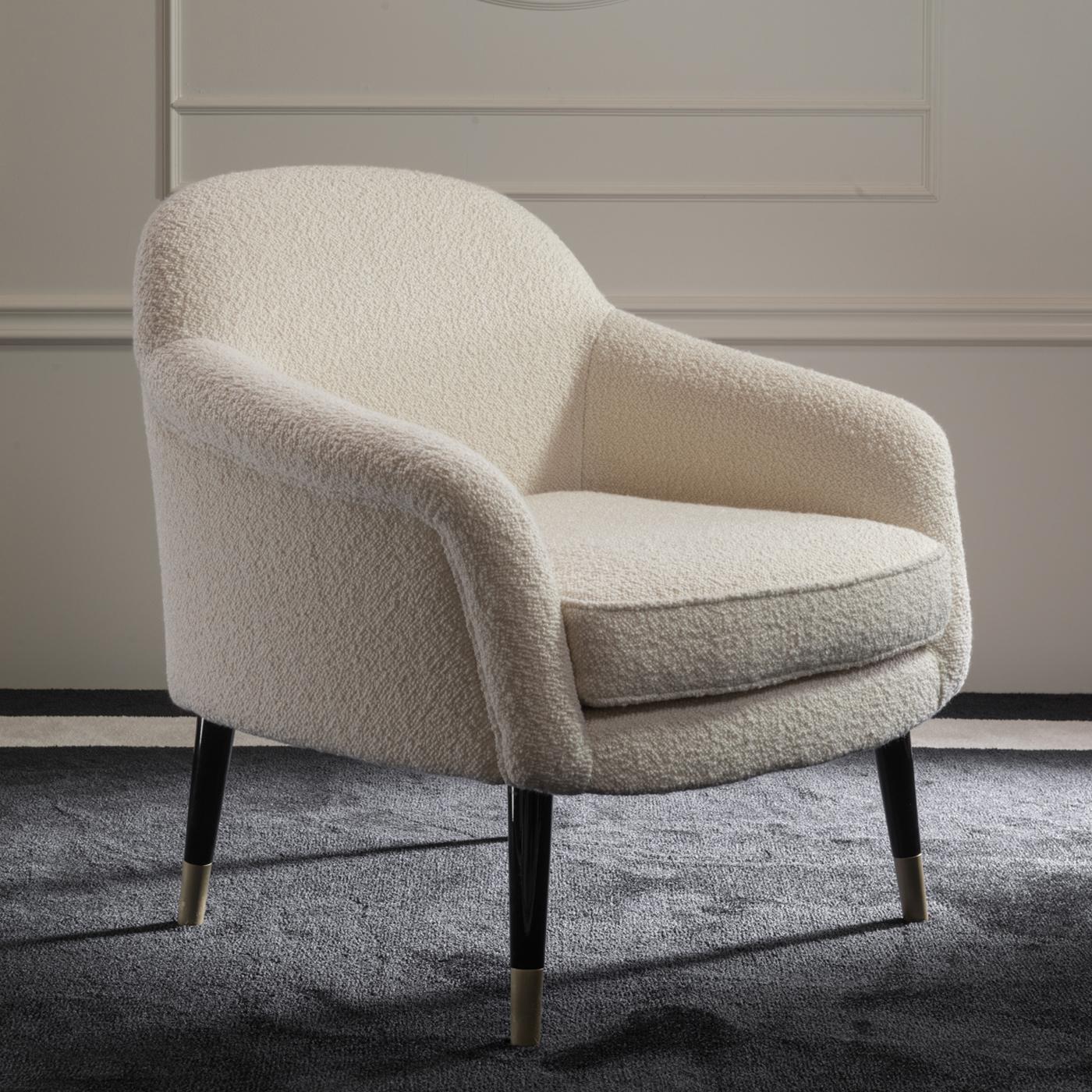 Part of the Bernadette collection, this elegant armchair is marked by simple, sinuous lines and elegant allure. The rounded back and enveloping armrests reinterpret the Classic bergere silhouette with a modern twist, with the velvety ivory