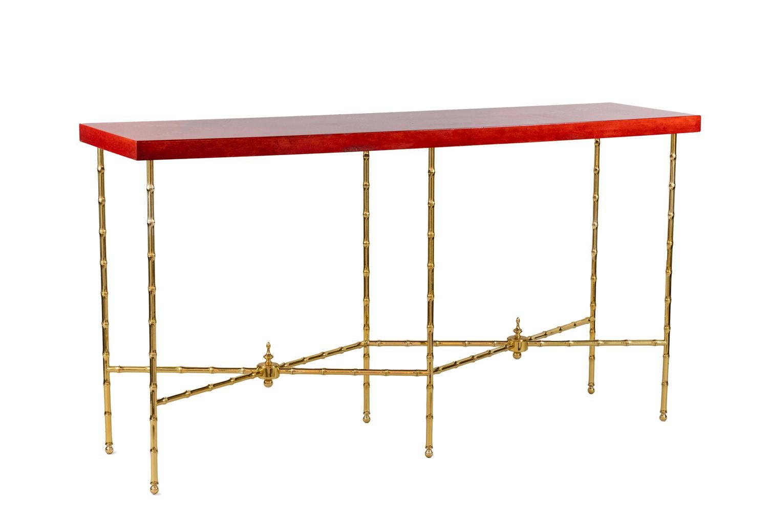 Bernard Dunand, signed.
Rectangular console standing on bamboo gilt bronze legs composed by six legs linked with each other by X stretchers centred by spinning tops.
Red lacquer tray with a gilt and brown Chinese decor of branches with