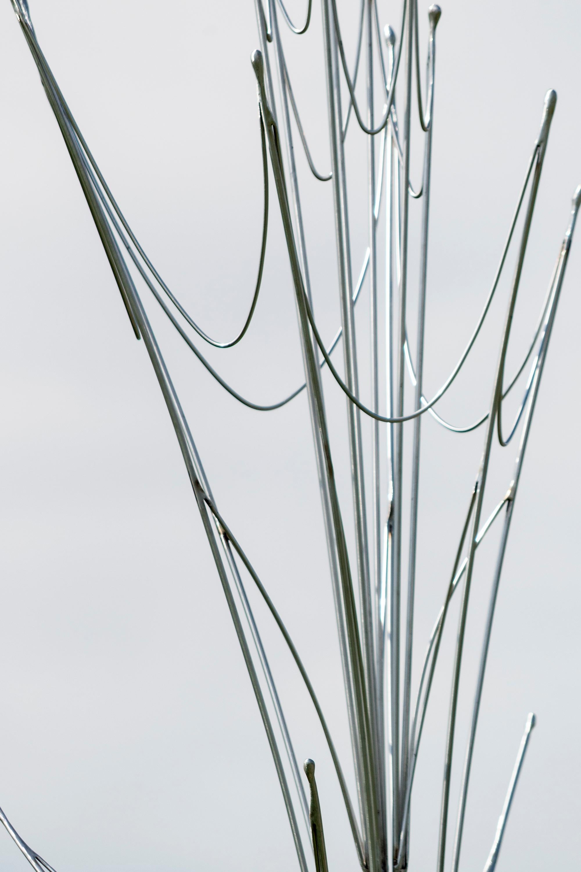 Quebec sculptor Bernard Hamel often looks to nature as a source of inspiration for his contemporary sculptures. Geyser emulates the fluid form of a spout of water erupting from the ground and shooting skyward. Forged from fine individual rods of