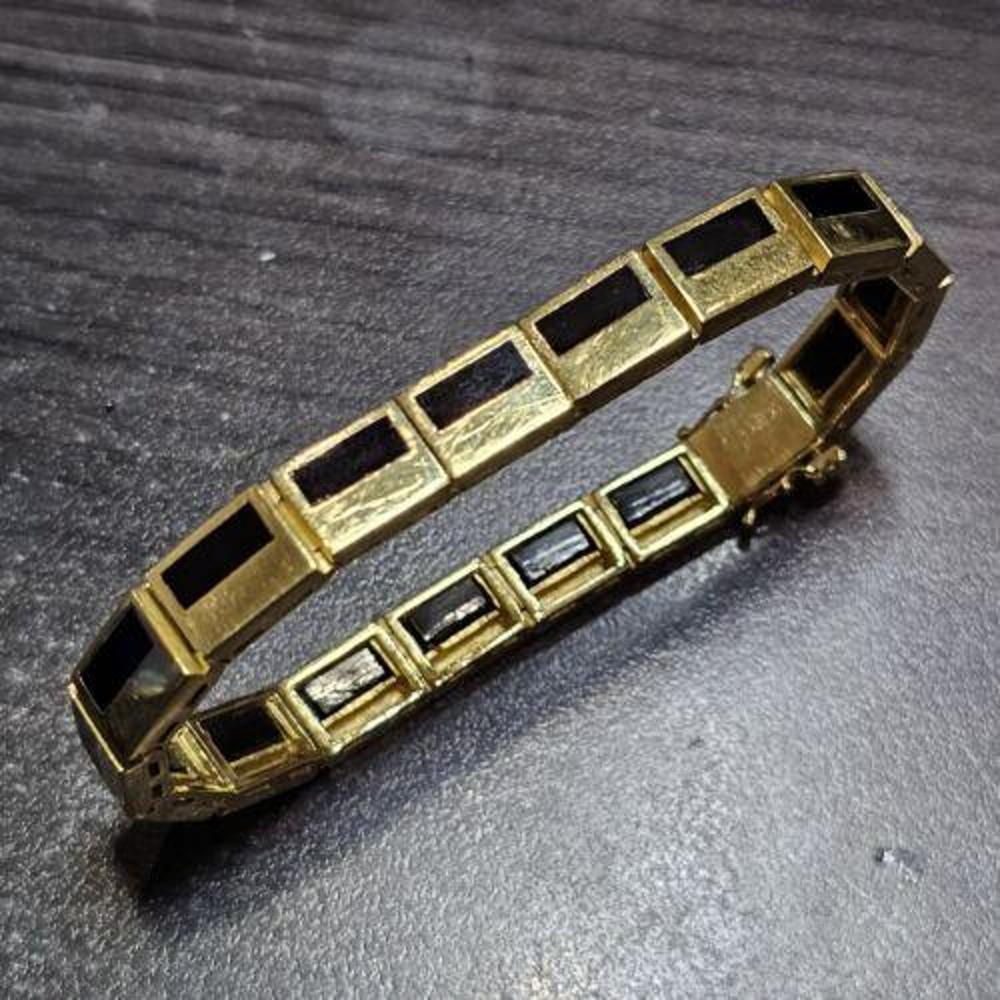 Dieses Armband von Bernard K. Passman ist ein atemberaubendes Schmuckstück, das Raffinesse und Eleganz ausstrahlt. Dieses Armband aus 18-karätigem Gelbgold besteht aus einer Kette mit einem auffälligen schwarzen Korallenstein als Hauptbestandteil.