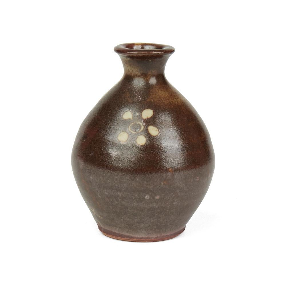 A stunning and rare miniature floral design Studio Pottery stoneware vase by Bernard Leach (1887-1979) and made at the Leach Pottery in St Ives, Cornwall. The small rounded bulbous shaped vase has a raised narrow neck and is decorated in mottled