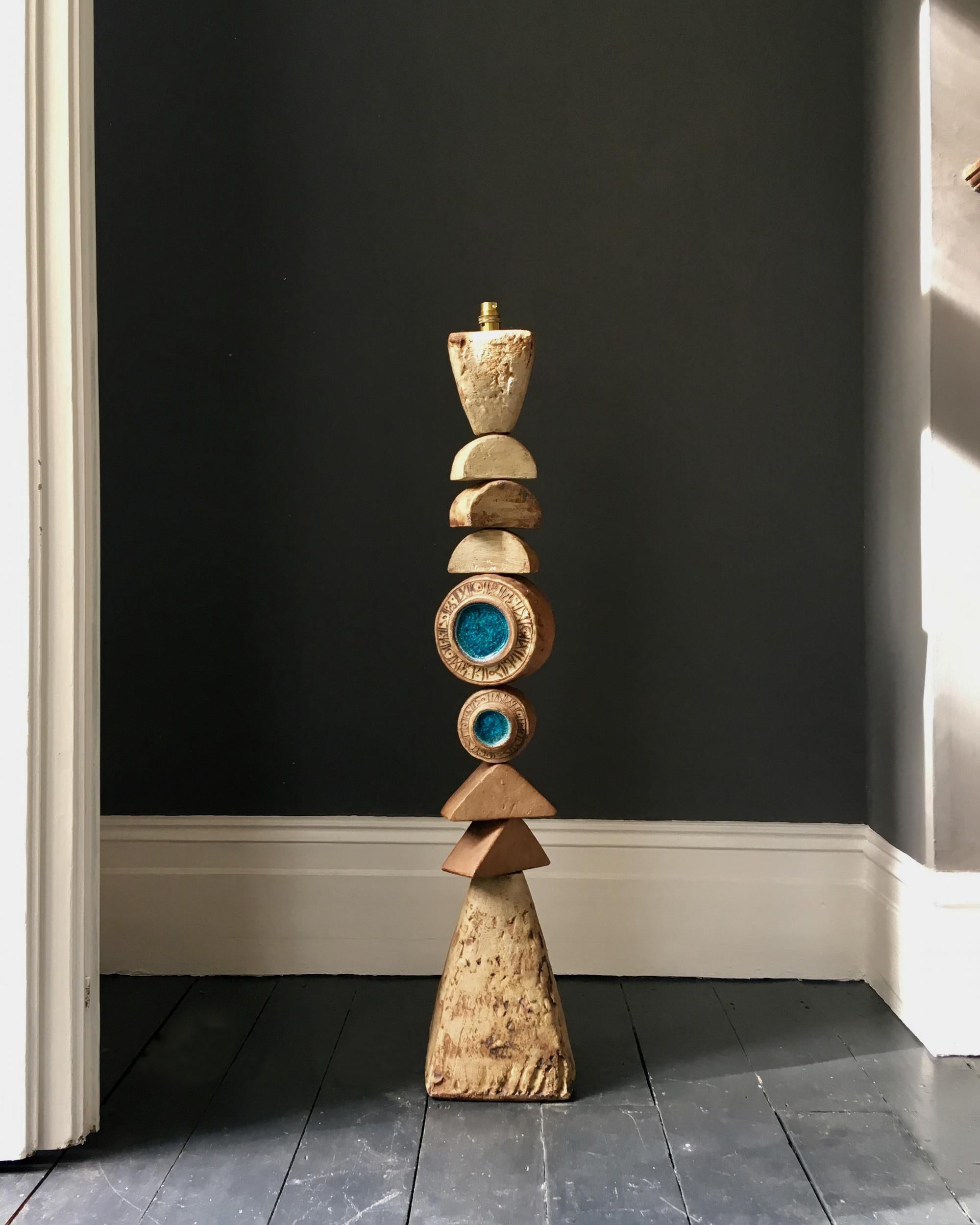A monumental ceramic TOTEM floor lamp by Bernard Rooke, England, 1960s.

A beautiful sculptural piece, made up of ceramic elements in natural tones of terracotta and stone. The two round elements are decorated on one side with blue glass (with a