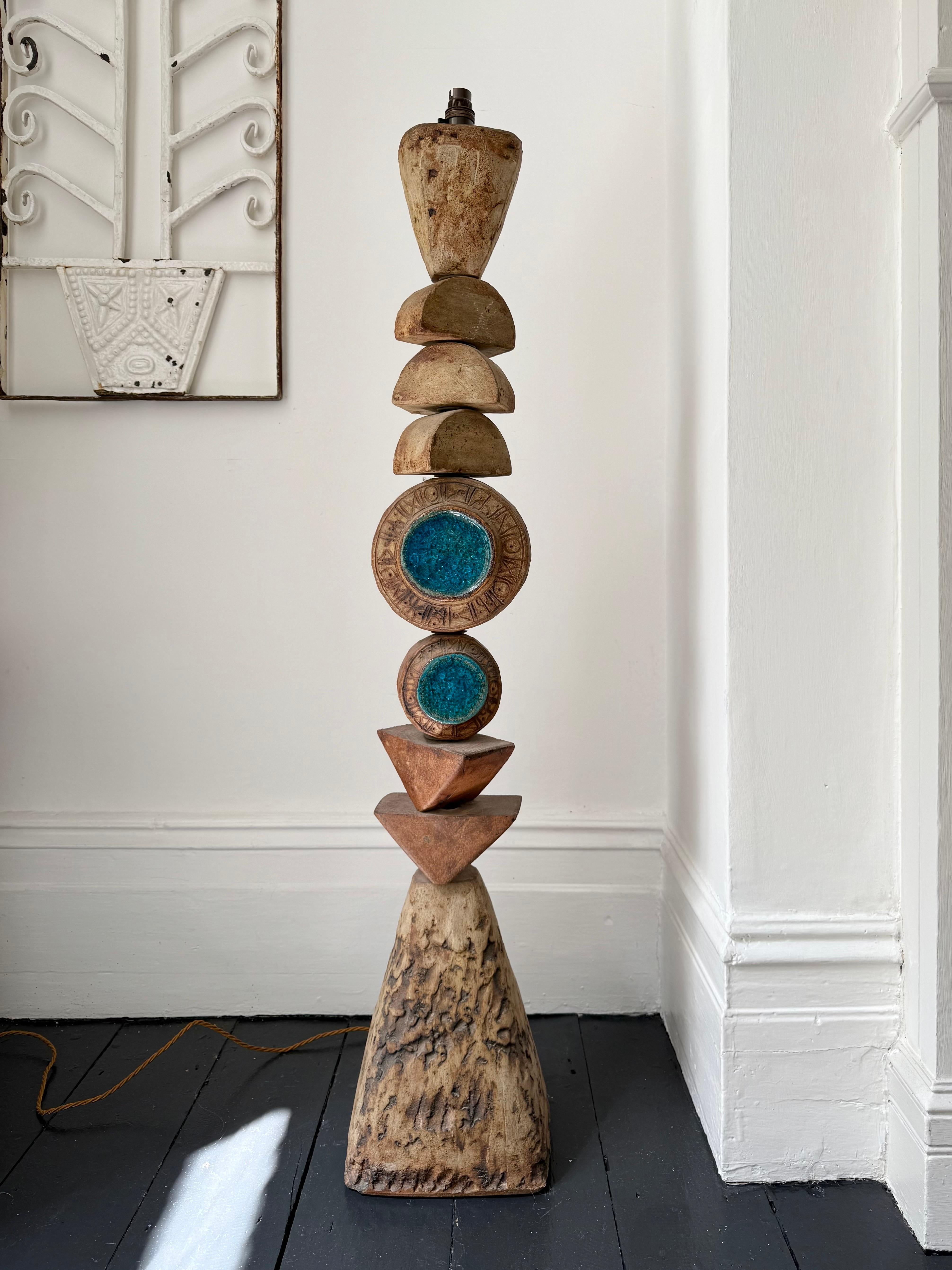 A monumental ceramic TOTEM floor lamp by Bernard Rooke, England, featuring two blue glass roundels. 

A beautiful sculptural piece, made up of ceramic elements in natural tones of terracotta and stone, with lots of texture, built over a metal tube.