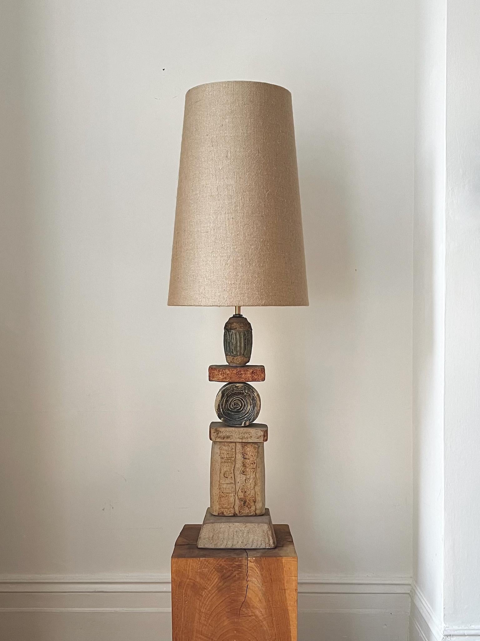 A large, or oversize, ceramic TOTEM table lamp by Bernard Rooke, England. 

This design is an early example of Rooke's work - probably 1960s - a sculptural piece in natural tones of terracotta and stone, with a combination of finishes. The lamp is