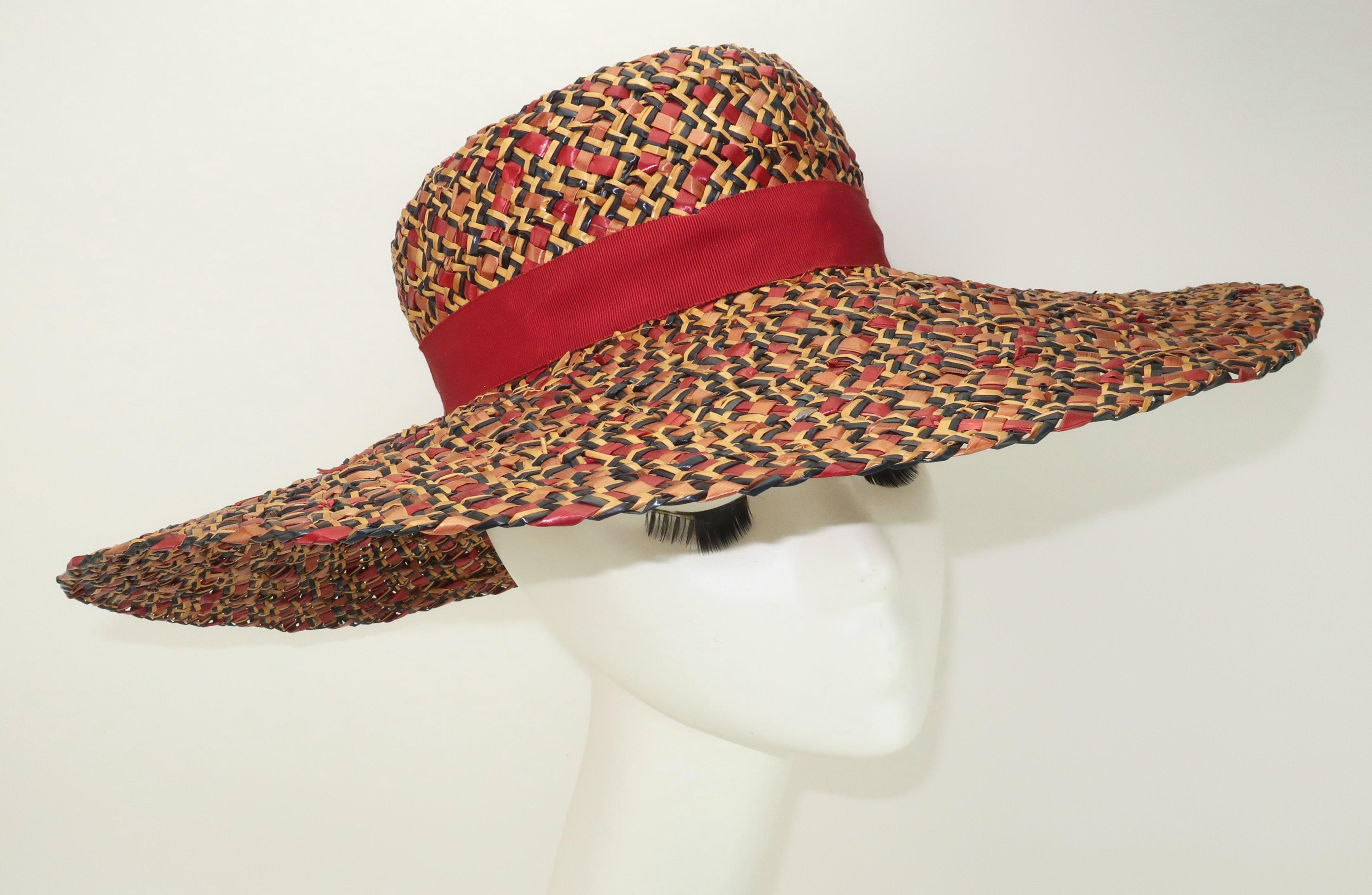 1940's wide brimmed straw hat designed by Alfred Weil for Bernard Workman milliners.  The combination of straw colors, including ruby red, navy blue and tan, provides the weave a tweed effect which is stylishly accented by a grosgrain ribbon band. 