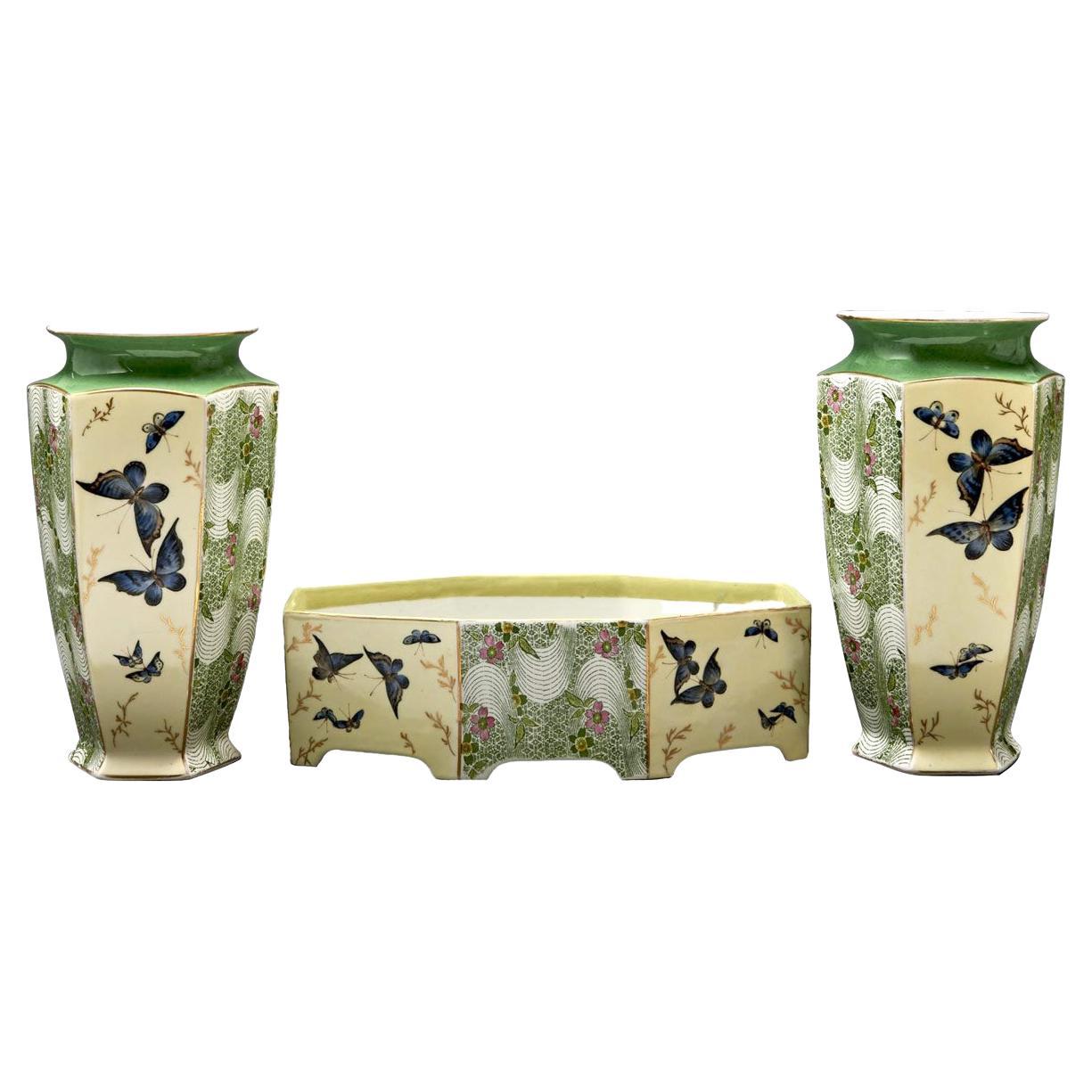 Very rare set of aesthetic movement Limoges porcelain composed of 2 vases and a planter.
The whole set is decorated with beige and green tones with lovely blue butterflies, in the perfect style of Japonism pieces. Vases and planter are with canted