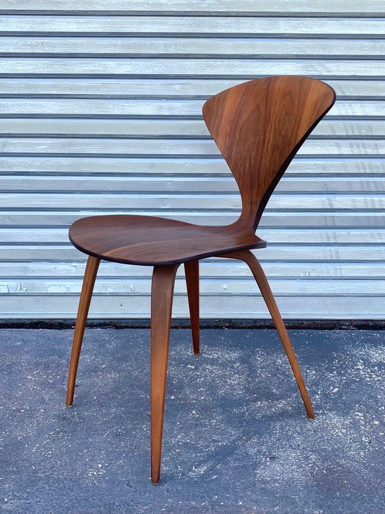 Early example of Norman Cherner’s “pretzel” chair designed for Plycraft. In beautiful original condition and original walnut finish. Delicately made with plys of strong wood demonstrating beautiful curves and angles. 

These chairs were