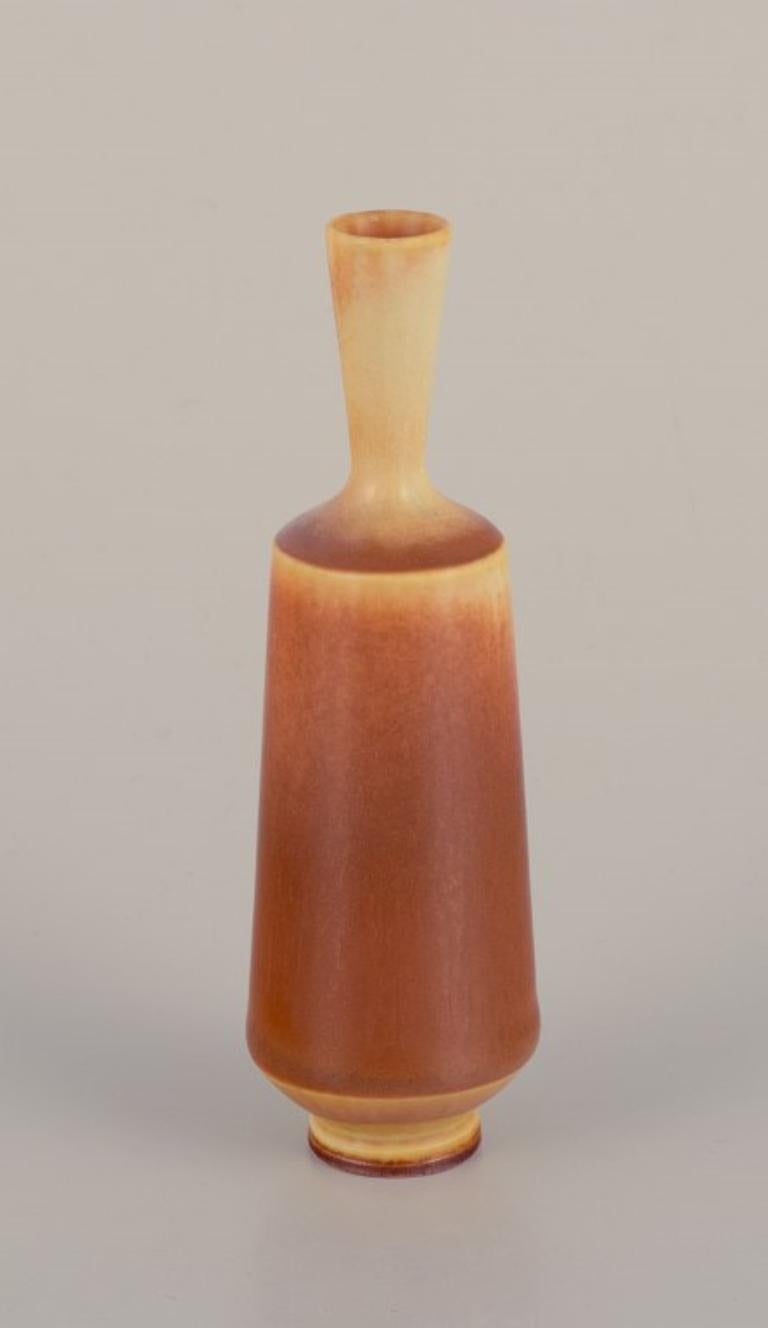 Berndt (1899-1981) pour le Studio Gustavsberg. 
Vase miniature à col étroit en céramique émaillée. 
Glaçure dans les tons jaunes et bruns.
Milieu du 20e siècle.
En parfait état.
Signé.
Avec la marque 