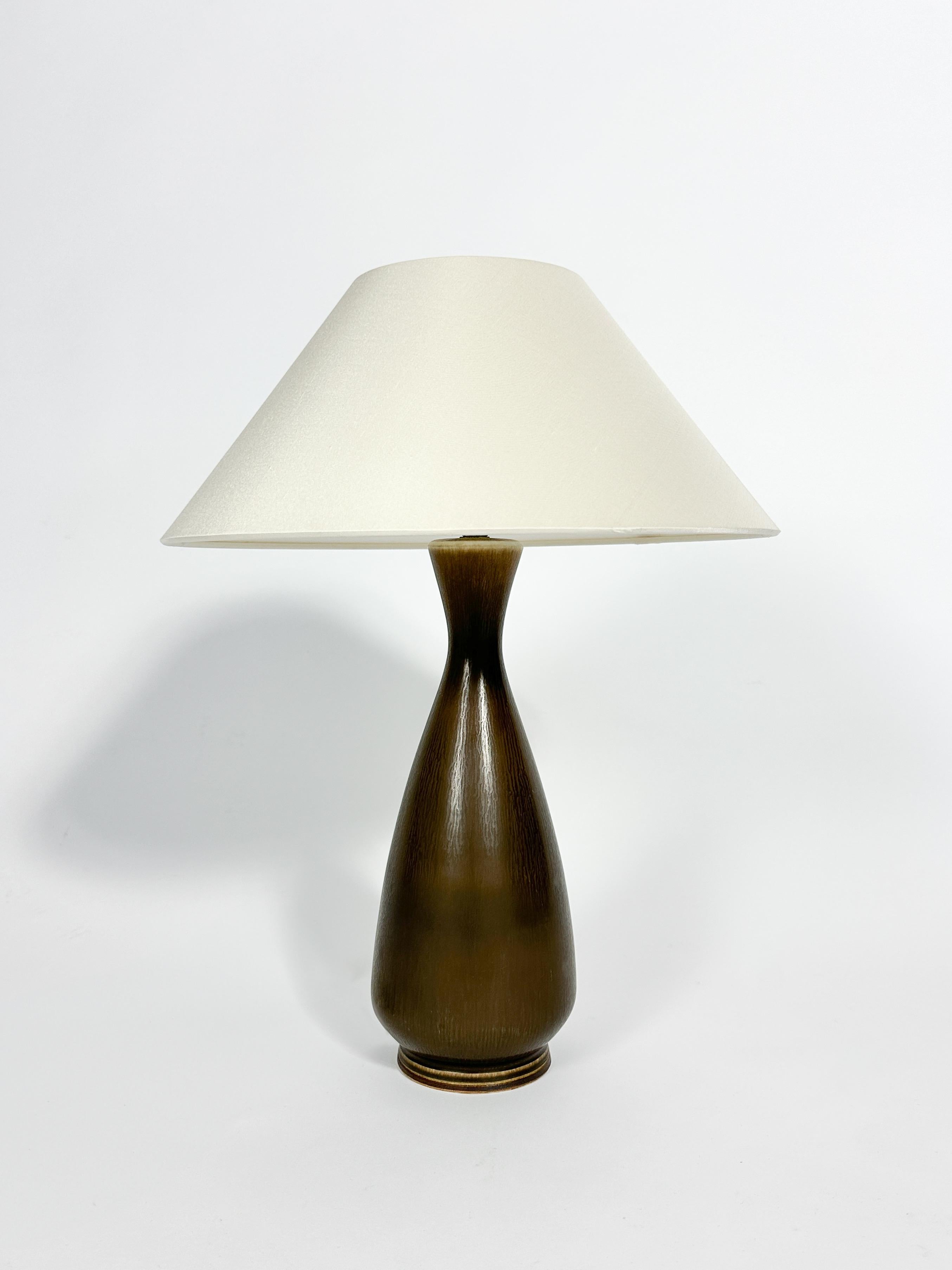 Una lampada da tavolo Berndt Friberg unica nel suo genere, realizzata in gres lavorato a mano con una perfetta smaltatura marrone a pelo di lepre, realizzata dal maestro stesso nel suo laboratorio di Gustavsberg, in Svezia, negli anni '70.

Altezza