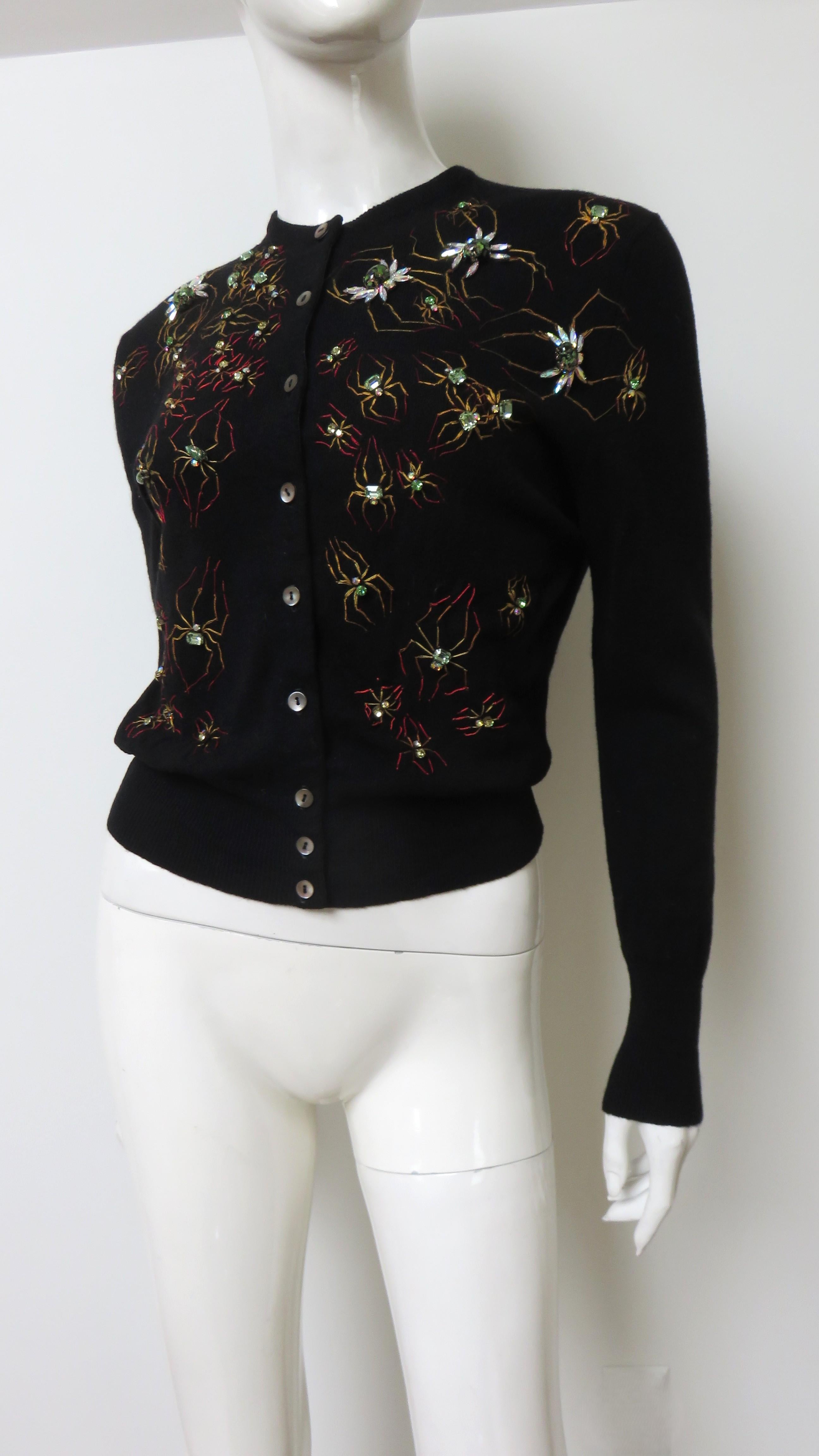 A gorgeous black cashmere cardigan sweater from Bernhard Altmann. It has long sleeves and a matching mother of pearl button front closing.  It is amazing covered in elaborate colorful glass stone, rhinestone, and embroidered spiders of varying sizes