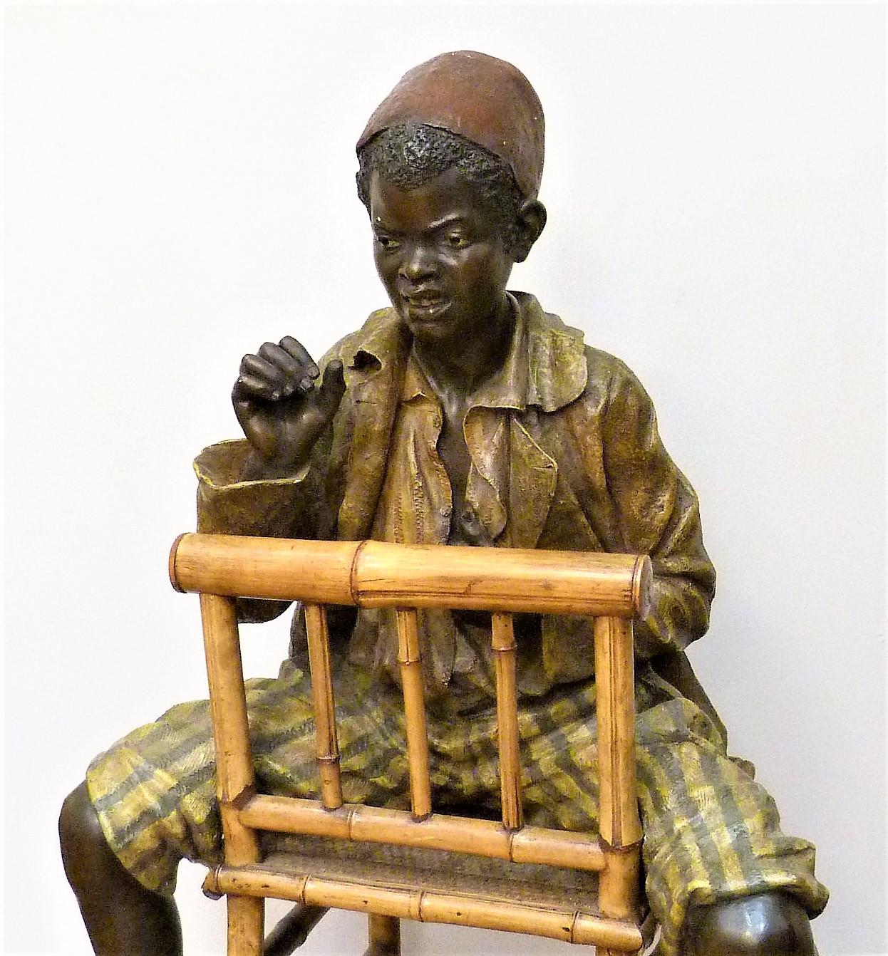 Very large polychrome terracotta decorated with a boy sitting astride a bamboo chair and basketry, numbered and monogrammed on the back. This sculpture is a feat of technicality and is found only exceptionally in this dimension, the editor has