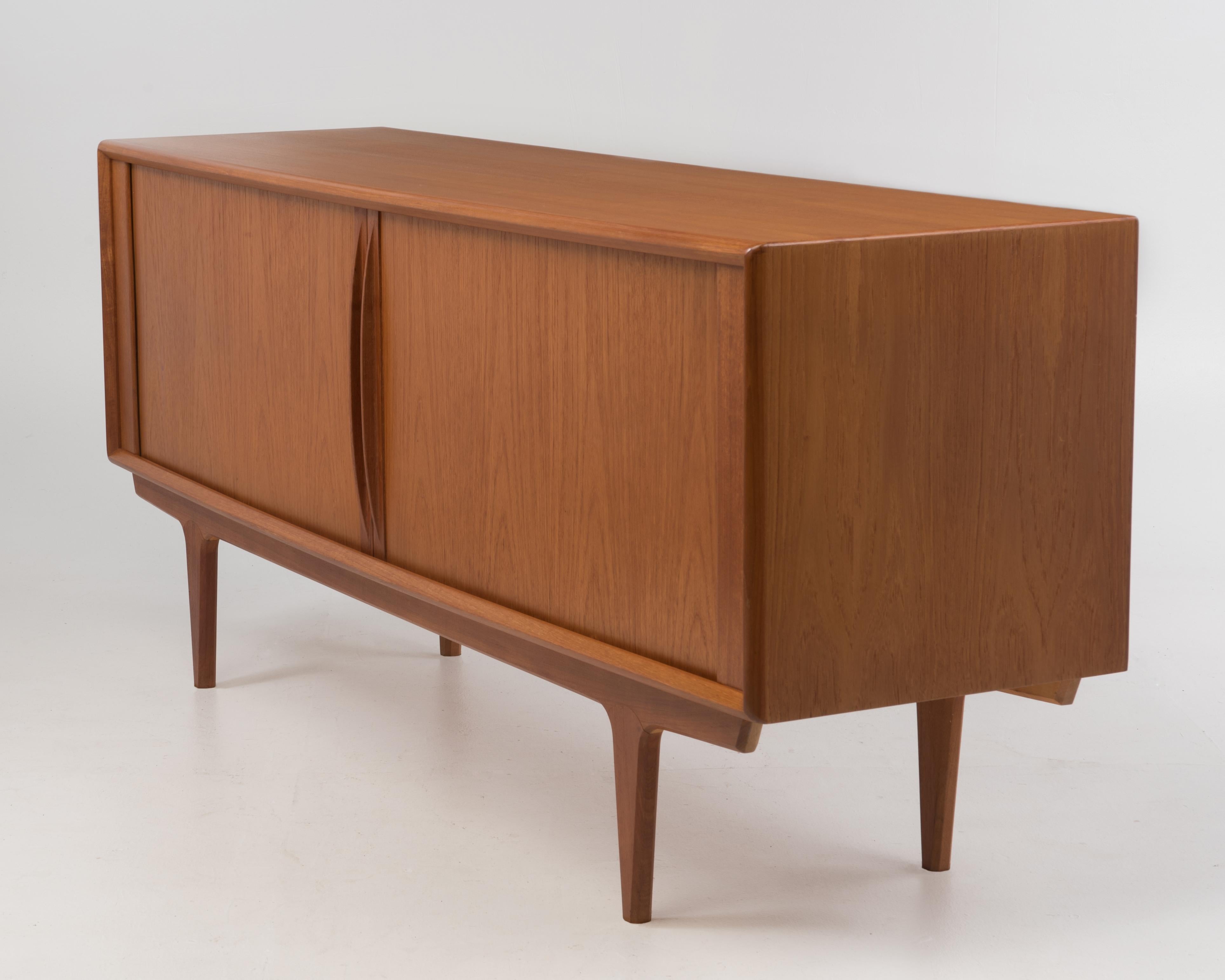 A vintage 1960s BPS, Bernhard Pedersen and Son Danish teak tambour door credenza attributed to Svend Aage Larsen. The top is subtly wider in the center, the depth of top in the center is 20