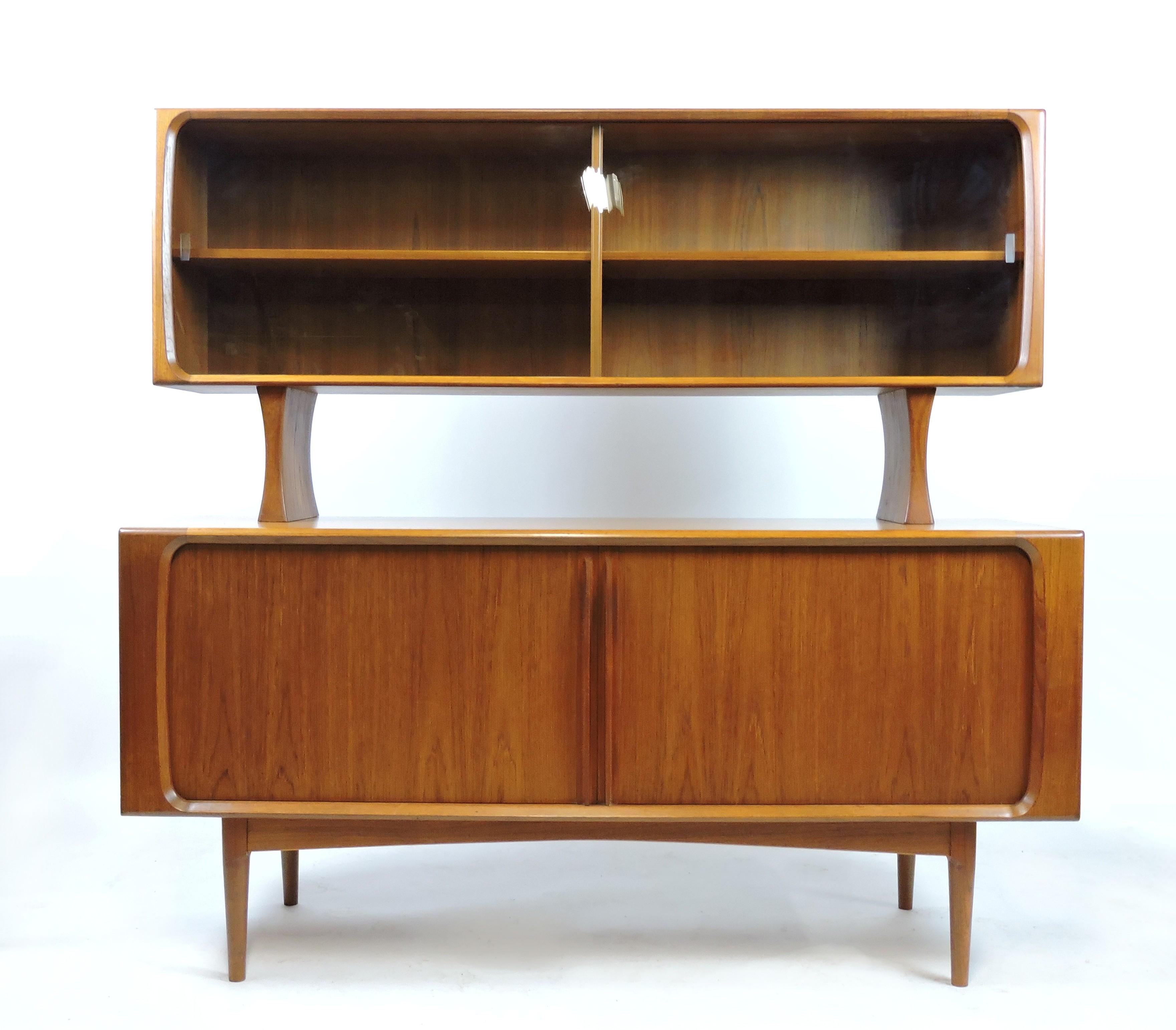 Handsome teak credenza and hutch, model 142/65, made in Denmark by Bernhard Pedersen and Son.

This well made cabinet has tambour doors with sleek sculpted teak pulls which open to reveal three dovetailed drawers and three adjustable shelves. The