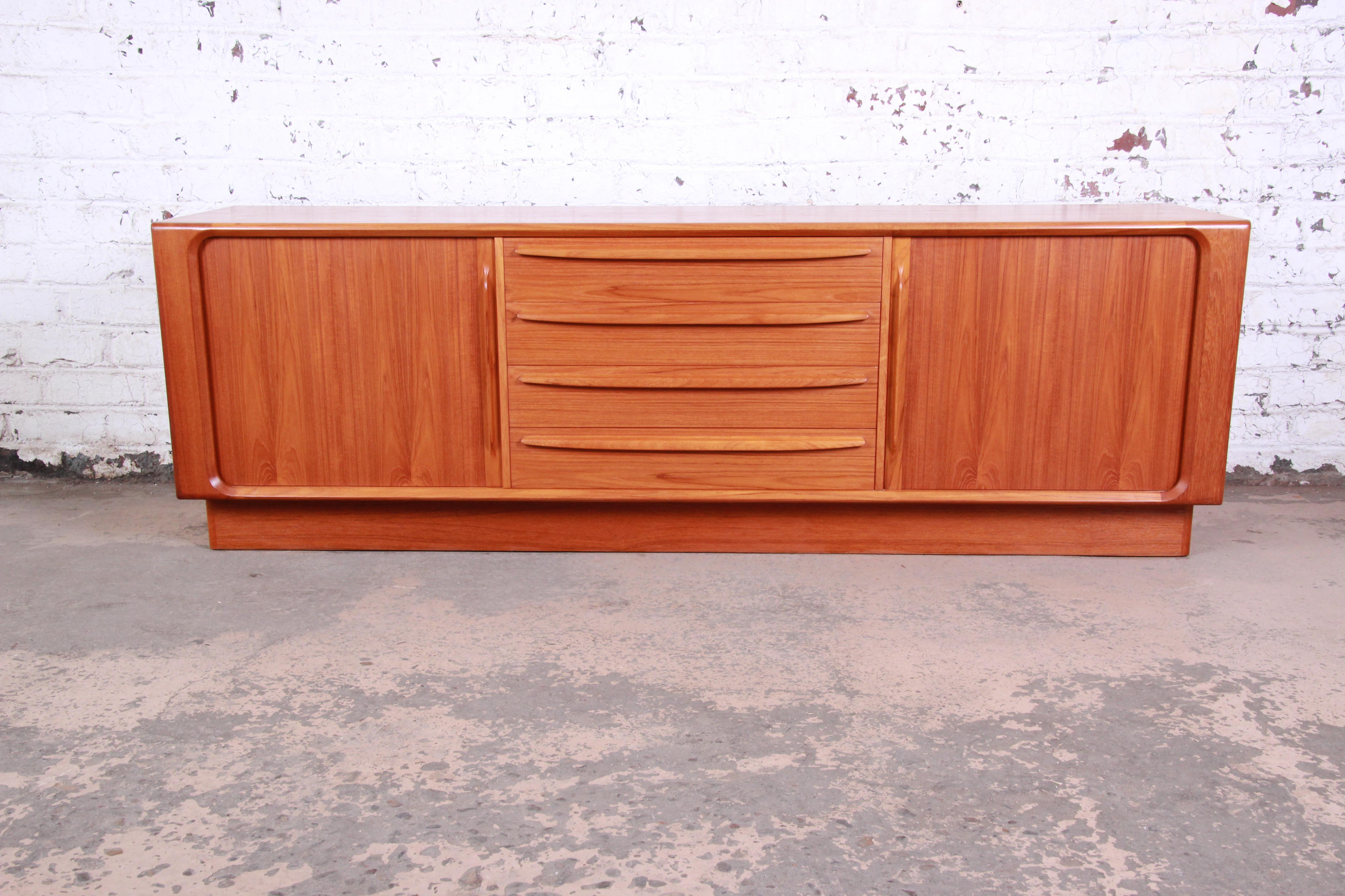 An exceptional midcentury Danish modern teak sideboard or credenza by Bernhard Pedersen & Son. The credenza features gorgeous teak wood grain and sleek Danish design. It offers ample storage, with seven dovetailed drawers and two shelves. The