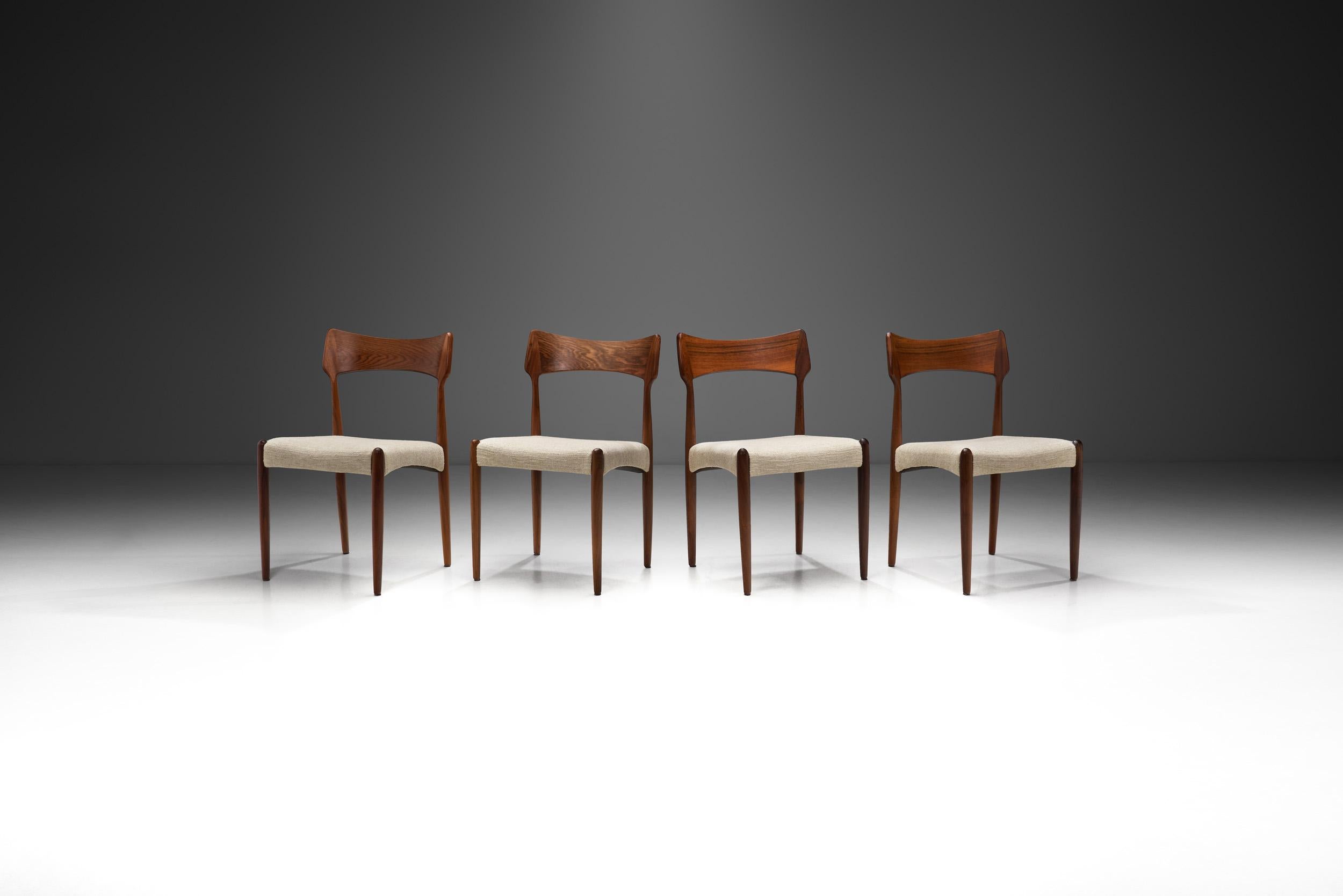 This gorgeous set of “model 142” chairs by the Danish furniture maker Bernhard Pedersen og Søn was inspired by classic Danish furniture design and simplicity. These exotic wood chairs feature typical Danish design elements with gracefully sculpted
