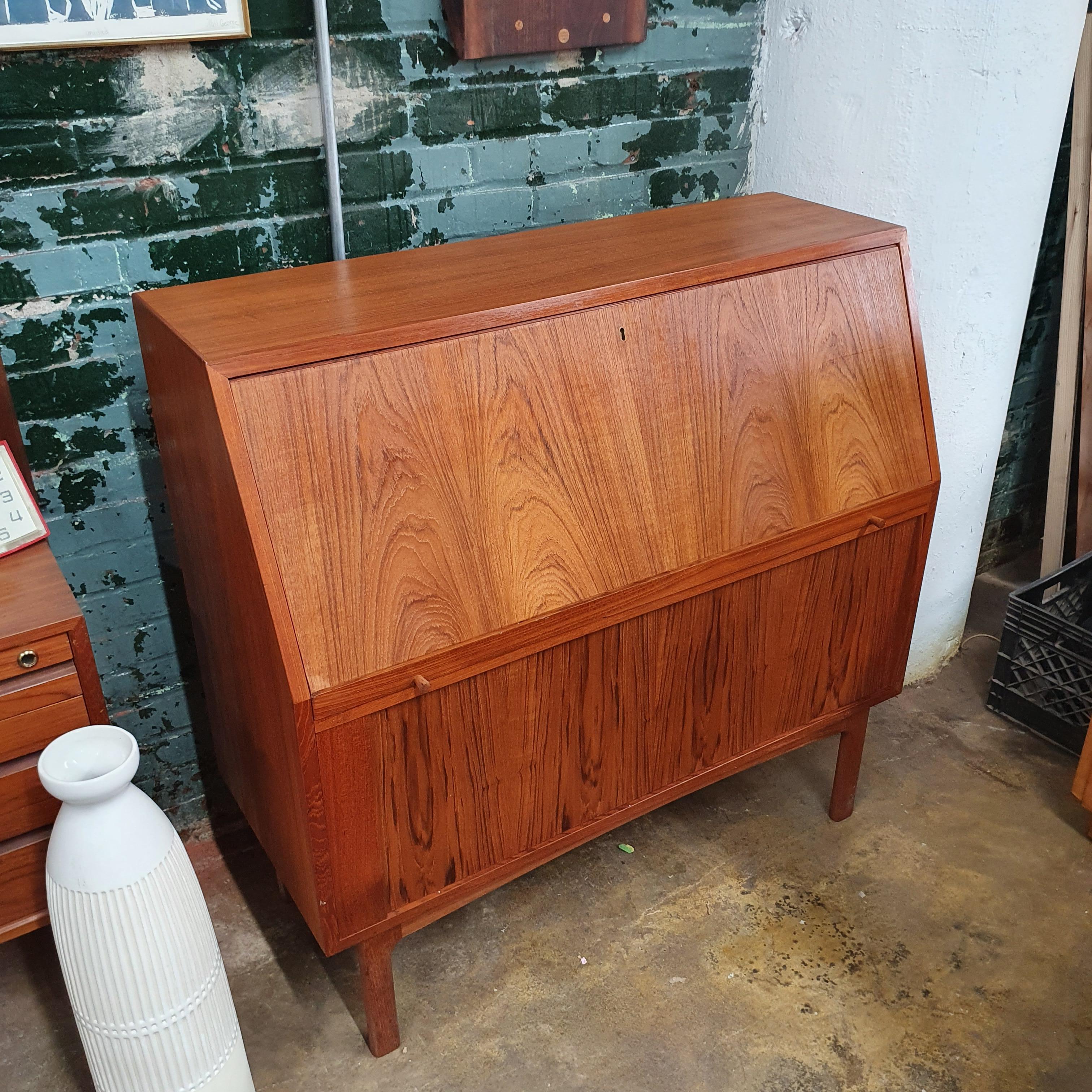 Beautiful teak secretary desk with tambour door by Bernhard Pedersen and Son. BPS. Drop front desk with 4 drawers inside. Some pictures shows desk on moving castors, not included.
