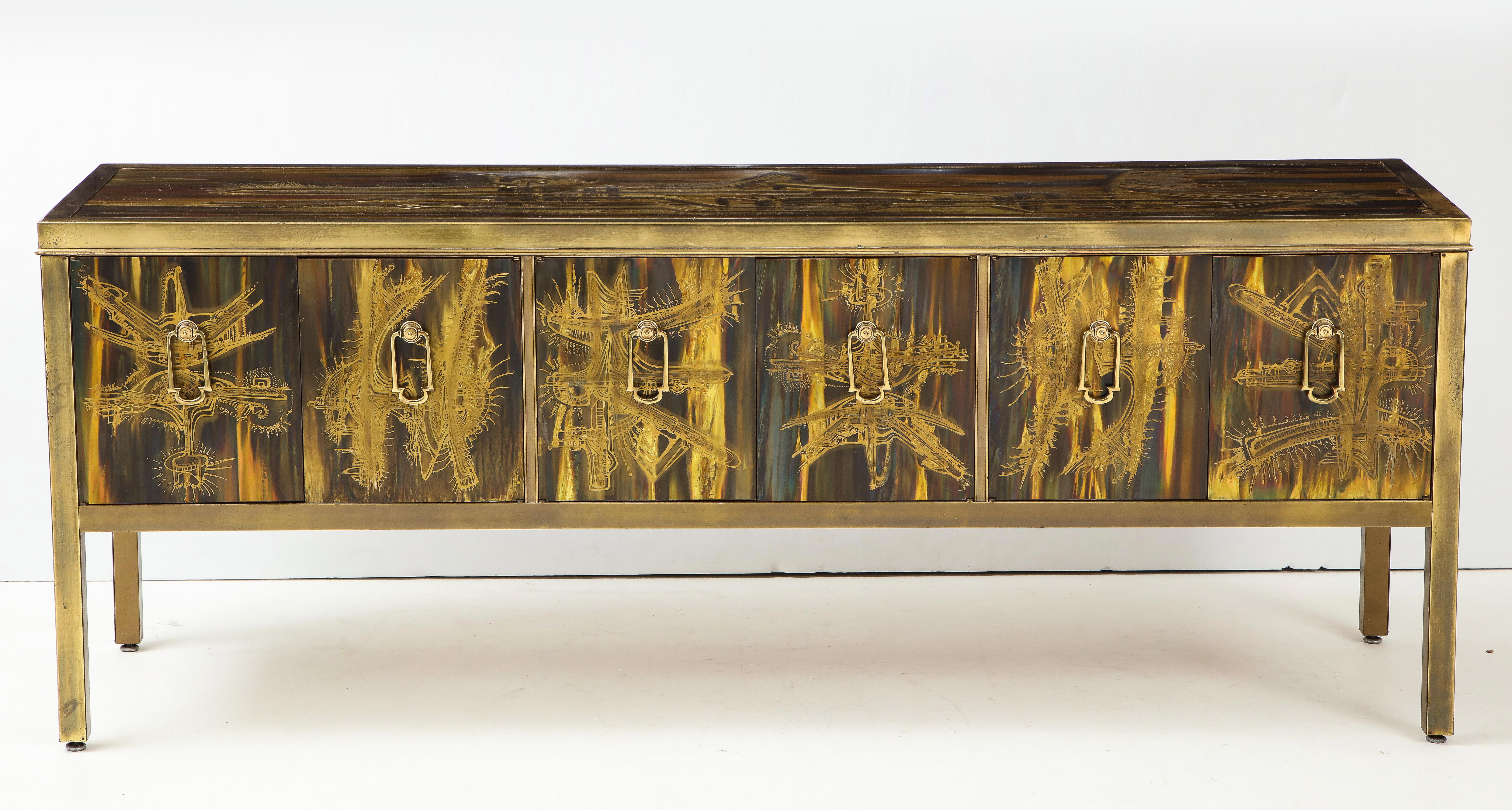 1970s chic acid etched ages brass credenza from one of the masters of metal, Berhard Rhone. The four panel doors feature brass doorknocker style brass pulls, while the case has aged brass framing surrounding the handwrought acid washed etched panels.