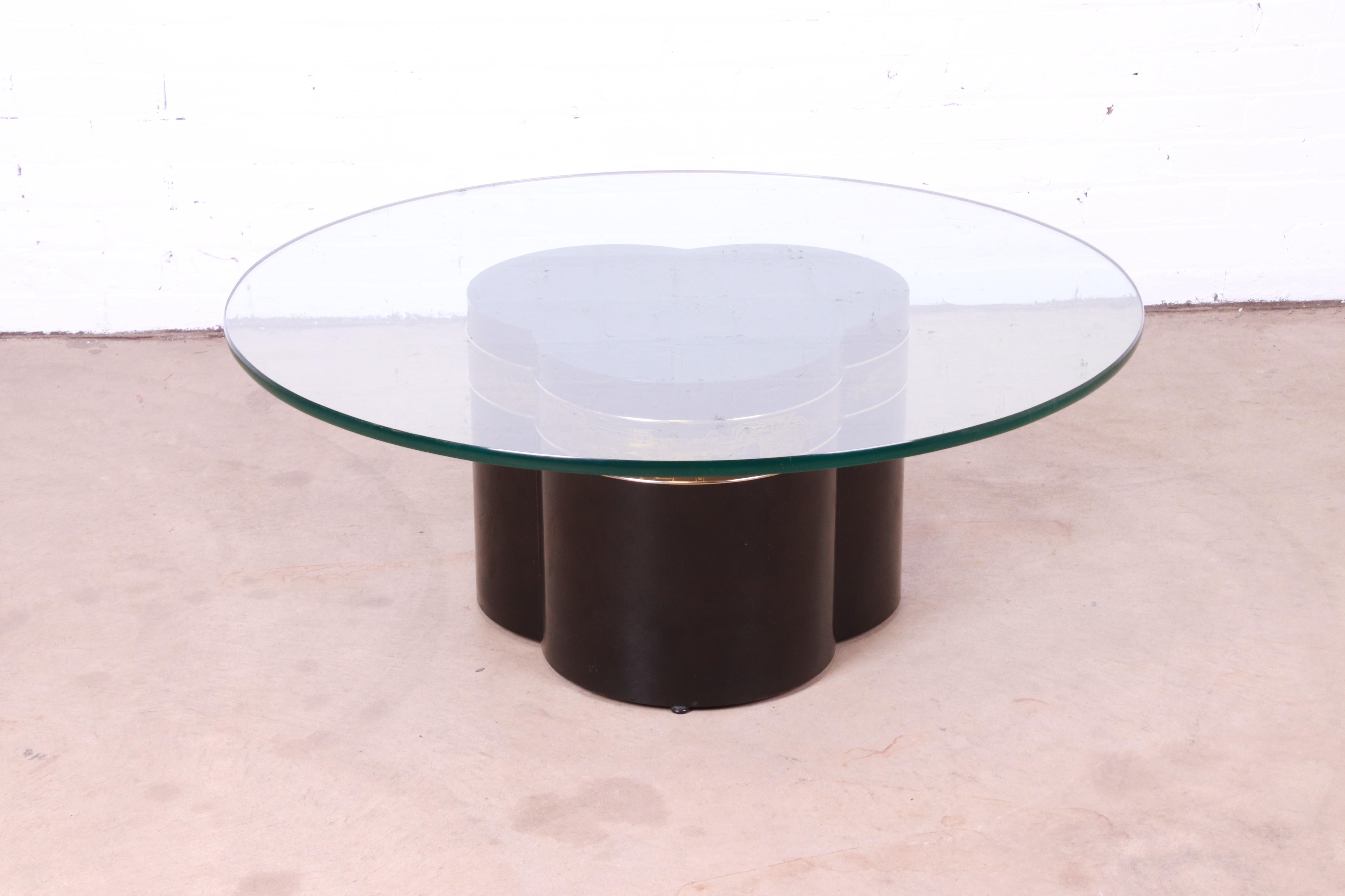 A gorgeous Mid-Century Modern Hollywood Regency coffee or cocktail table.

By Bernhard Rohne for Mastercraft Furniture.

USA, 1970s

Black lacquered trefoil form base, with acid etched brass design and thick round glass top.

Measures: 42