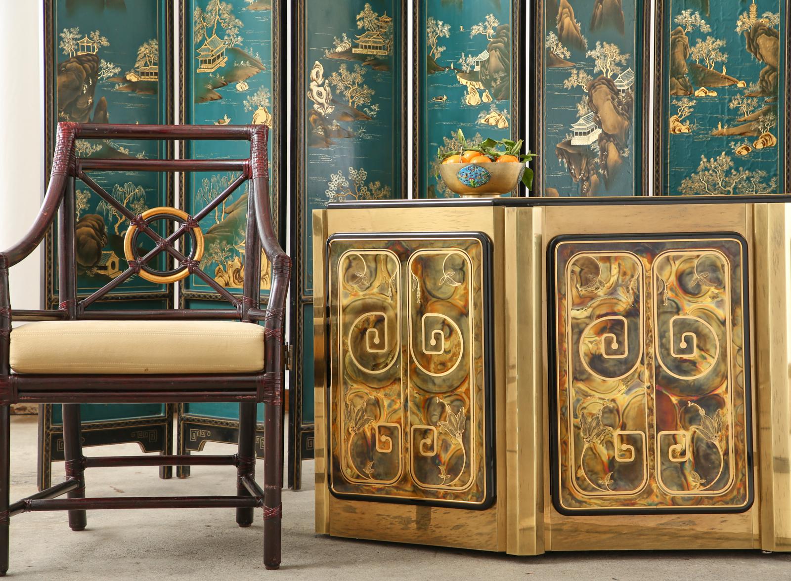 Stunning brass cabinet or credenza designed by Bernhard Rohne for Mastercraft. The cabinet features three panels and a top that have been acid etched. The panels are decorated with a Greek key design accented by flowers, and the top has a dramatic