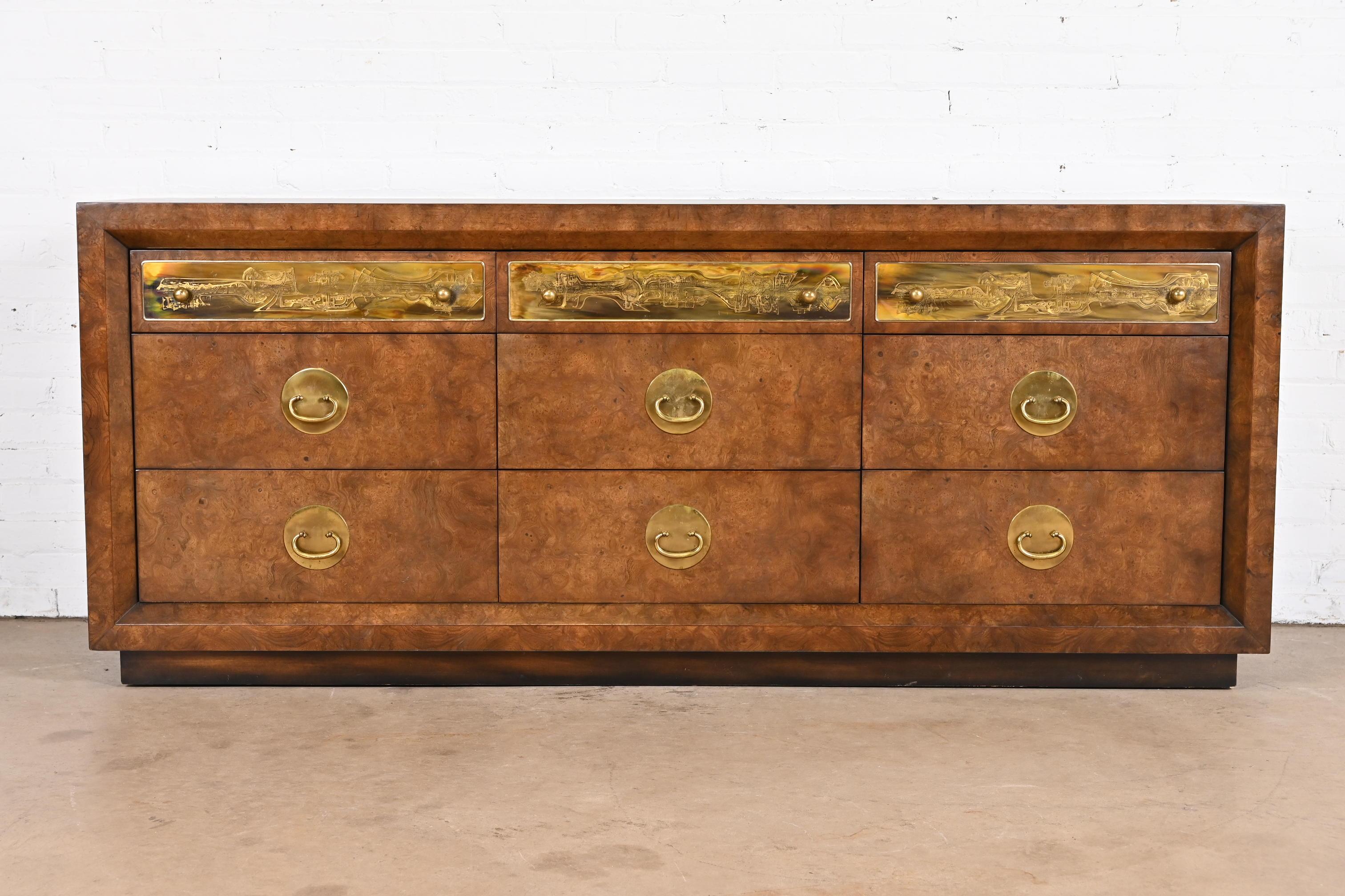 A gorgeous mid-century modern Hollywood Regency triple dresser or credenza

By Bernhard Rohne for Mastercraft Furniture

USA, 1970s

Burled Carpathian elm wood, with acid etched brass drawer fronts and original brass hardware.

Measures: 78